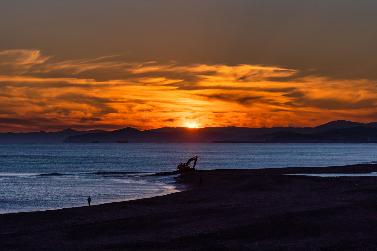 Hermoso atardecer reflejándose en el mar con una persona en silueta