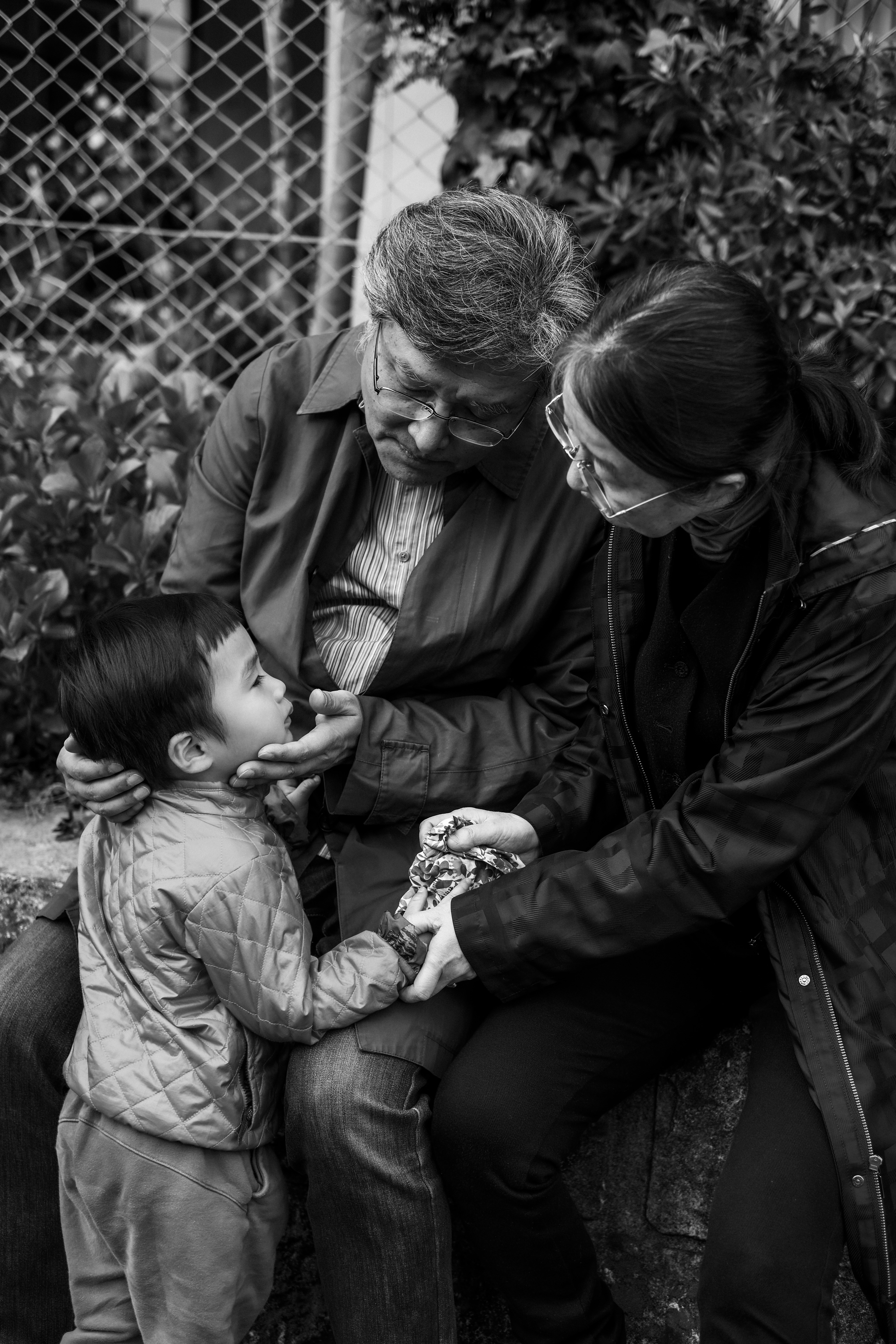 mains de famille réconfortant un enfant assis sur un banc