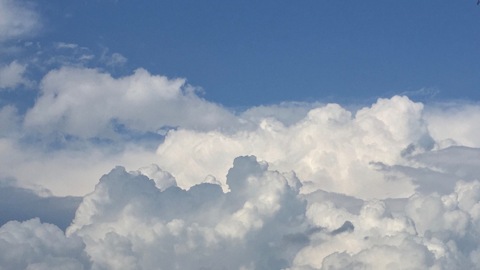 Fluffy white clouds in a clear blue sky