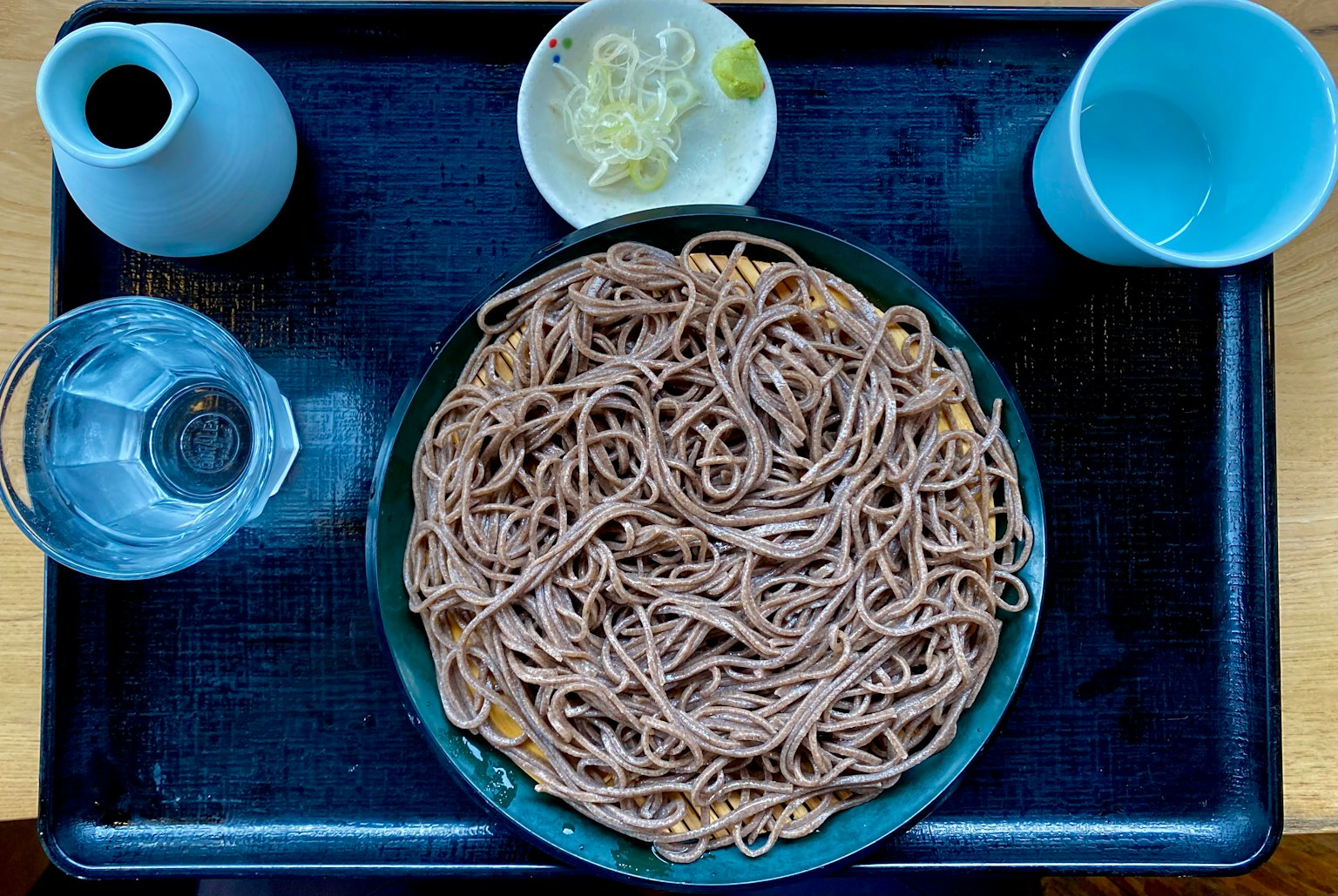 Piring mie soba dengan bumbu dan minuman