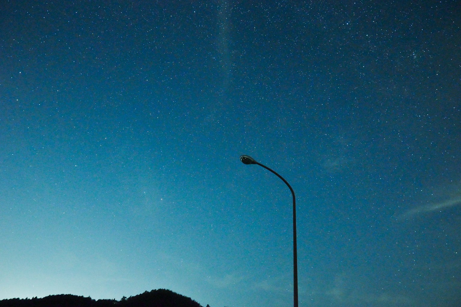 Starry night sky with a silhouette of a streetlight