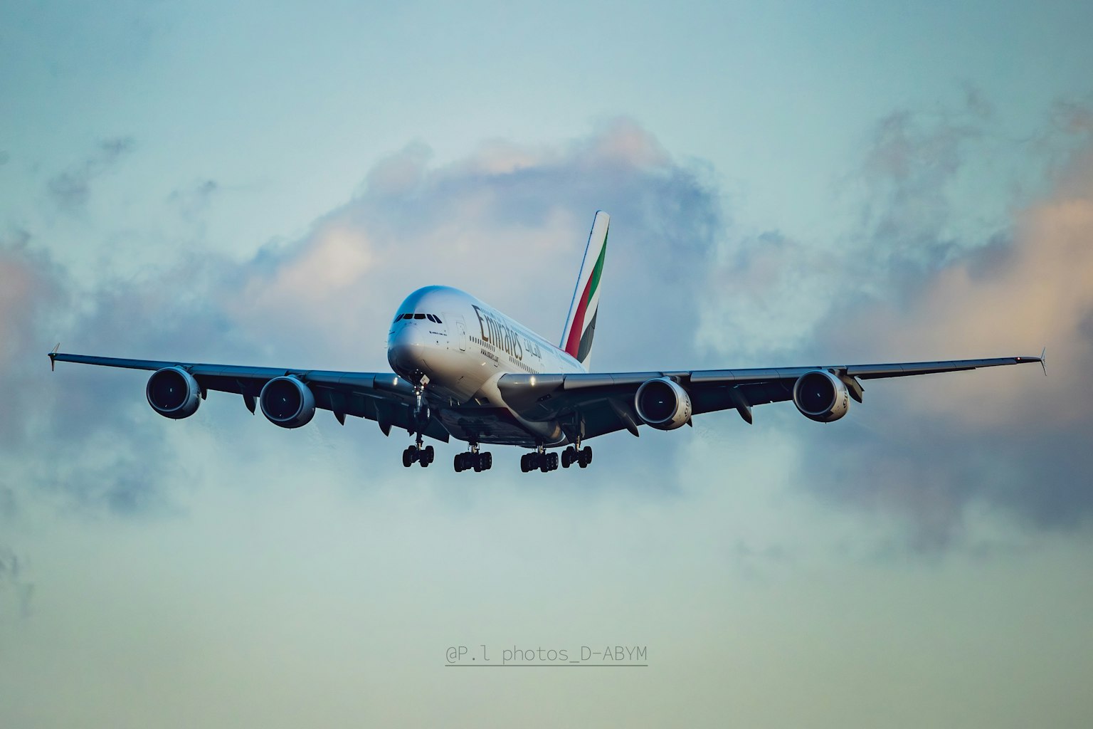 Emirates A380 airplane flying against a blue sky