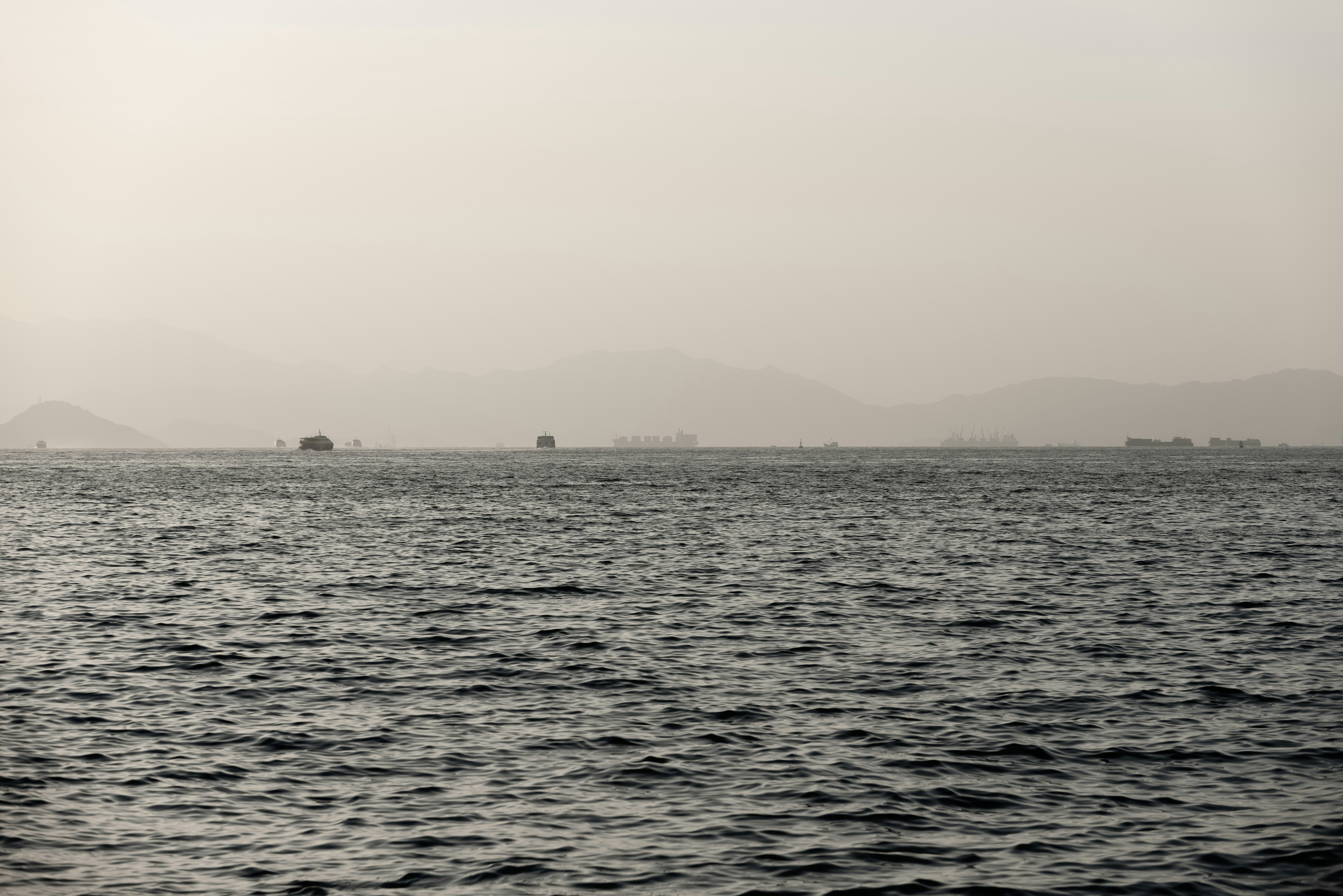 霧のかかった海と遠くの山並みを望む海上の風景