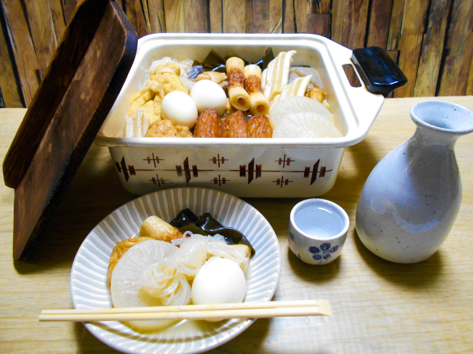 Una foto di oden servito in una pentola e un piatto con vari ingredienti come daikon e uova