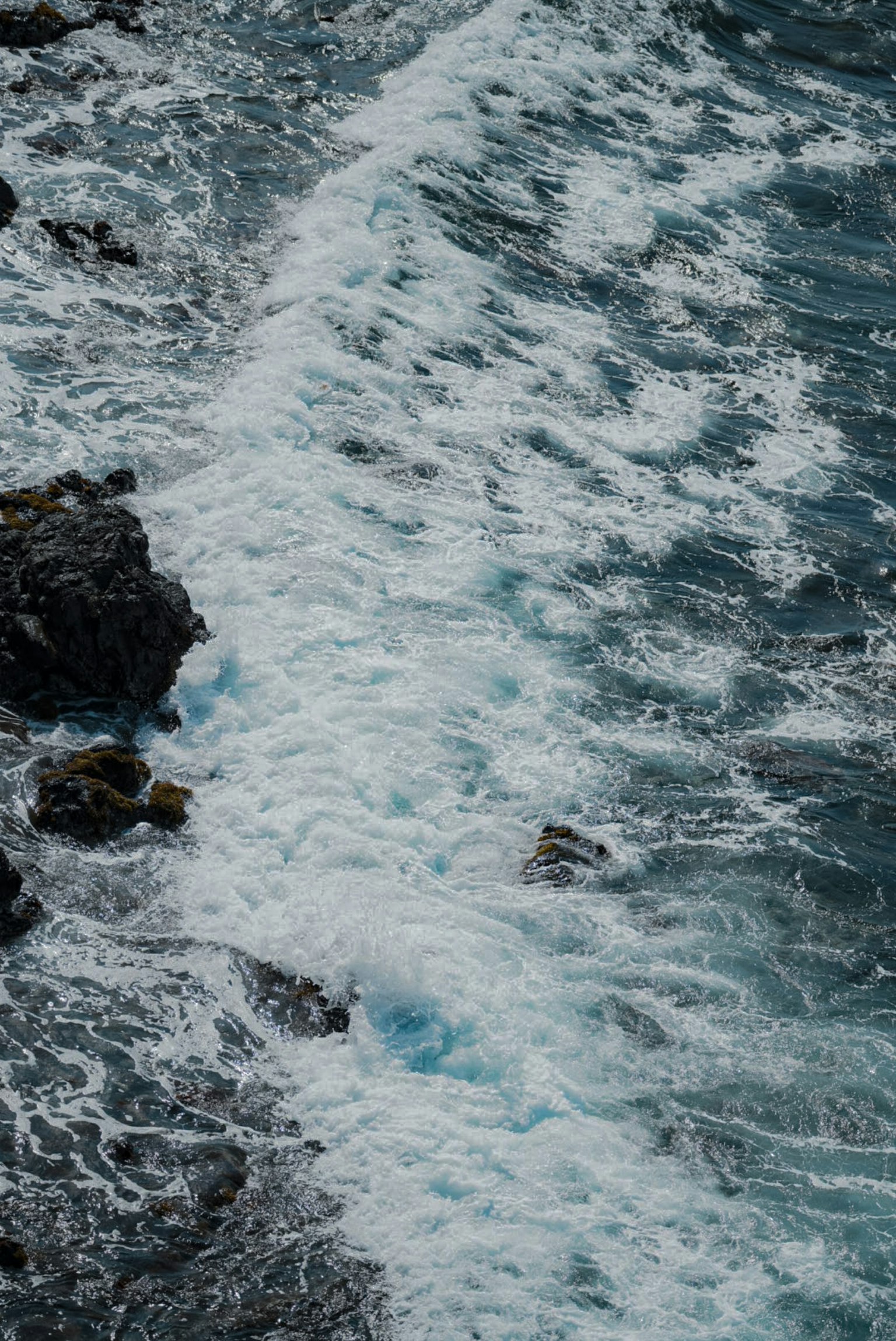 海浪拍打岩石的場景 藍色水和白色泡沫