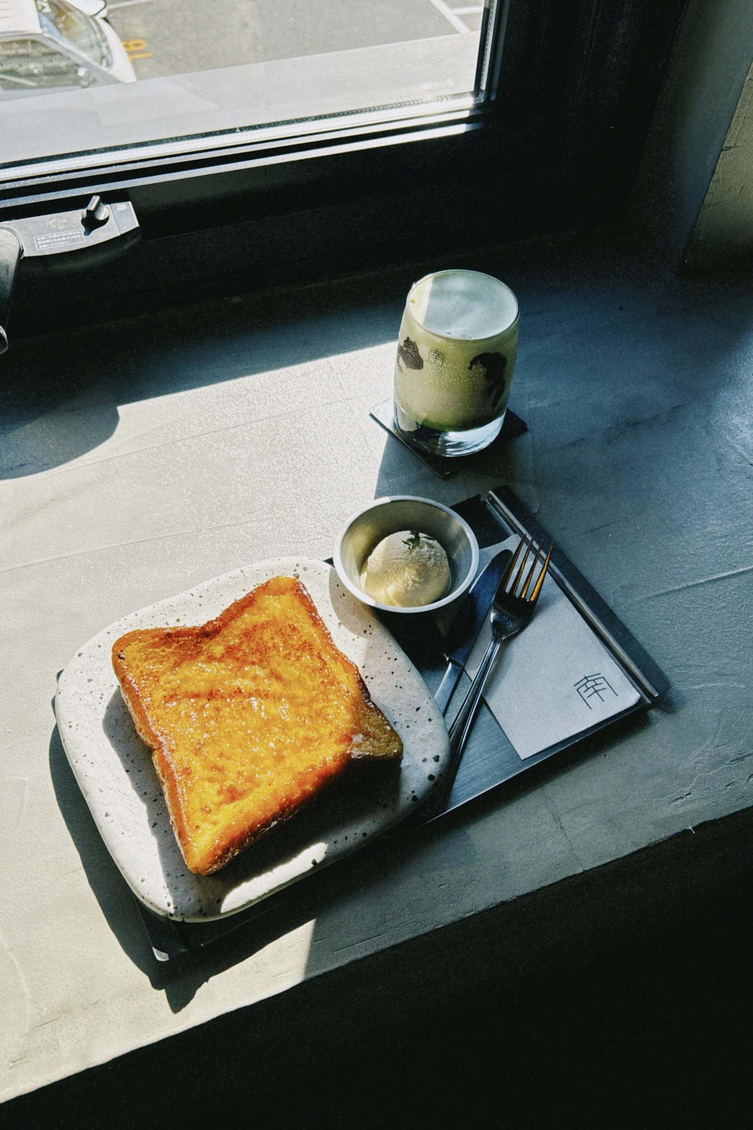 Eine Mahlzeit mit Toast und Eis, die am Fenster platziert ist