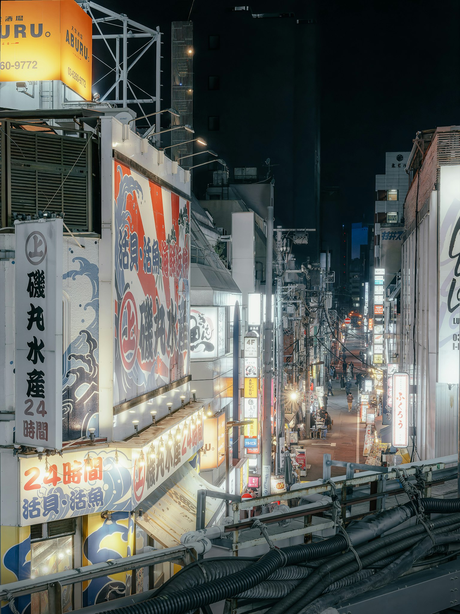 ถนนในเมืองที่มีชีวิตชีวาในเวลากลางคืนพร้อมป้ายไฟนีออนและโฆษณา