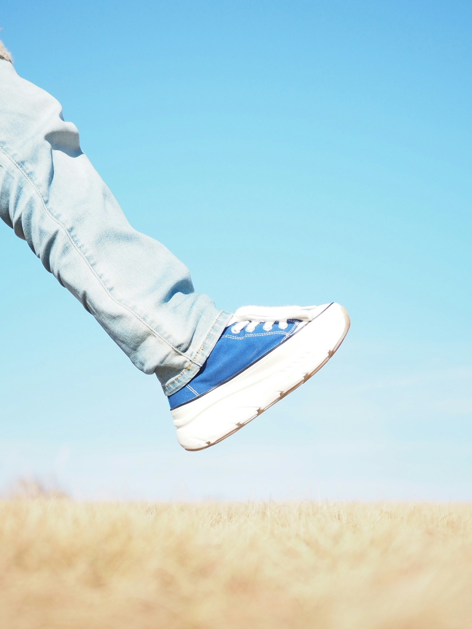 Pied portant des baskets bleues levé dans les airs