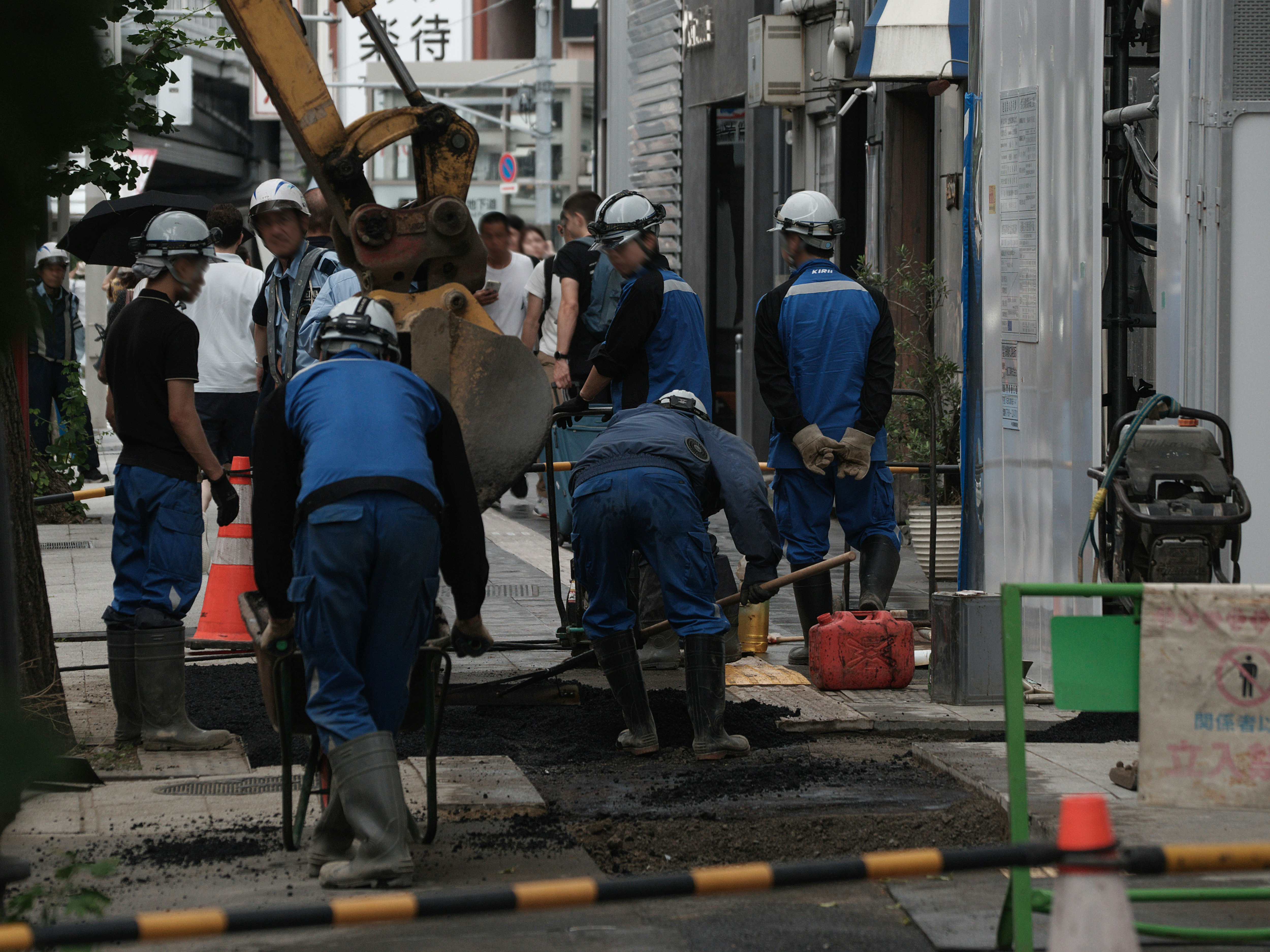 Pemandangan jalan dengan proyek perbaikan trotoar, pekerja mengoperasikan alat berat