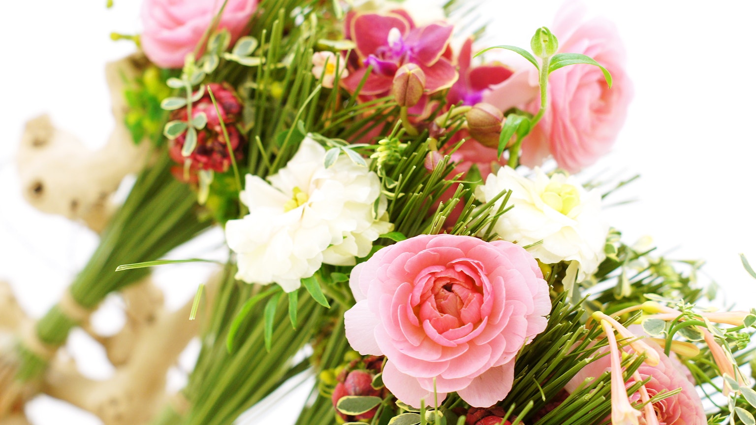다양한 색상의 꽃다발로 핑크색 라나쿨루스와 흰꽃이 있습니다
