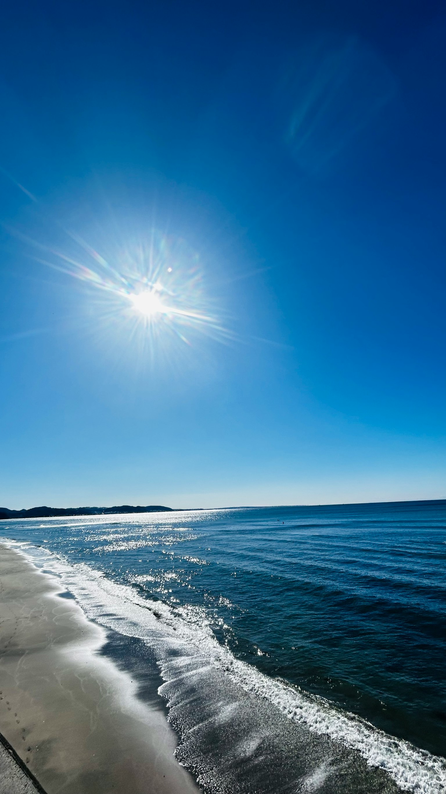 Vue pittoresque de l'océan bleu et de la plage de sable blanc avec un soleil éclatant