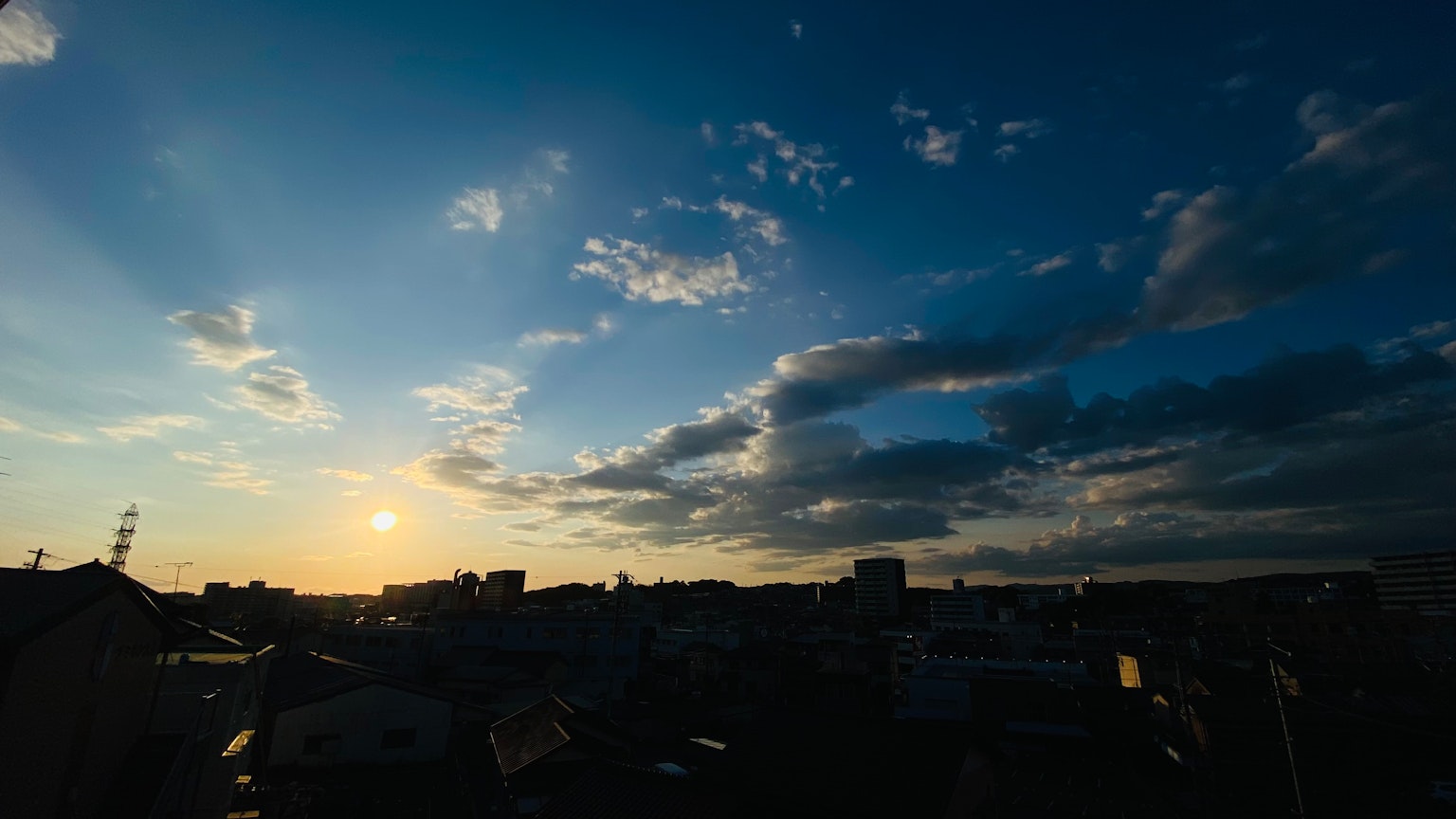 Stadtlandschaft unter einem Sonnenuntergangshimmel mit Wolken