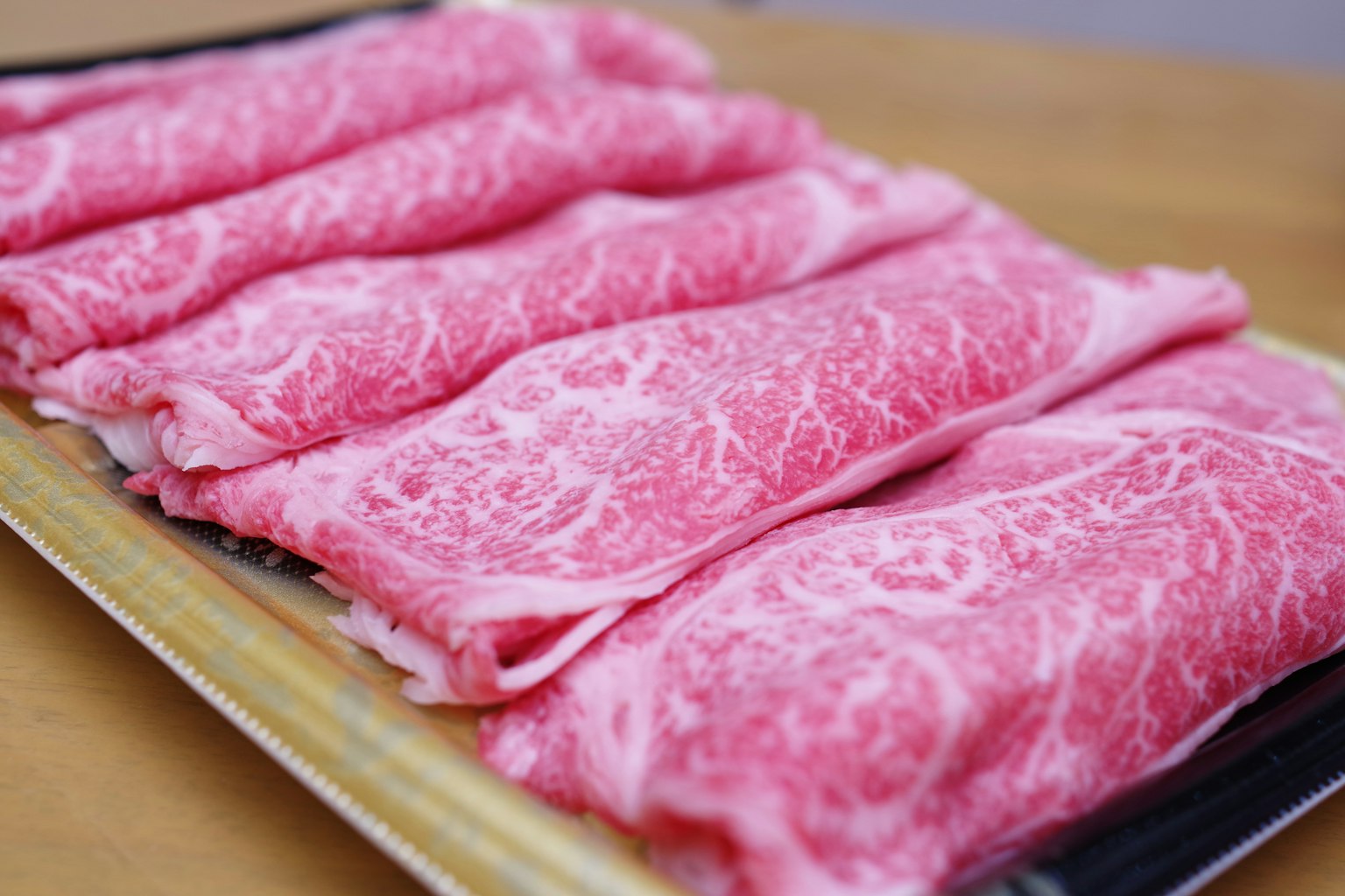 Daging sapi tipis dengan pola marmer yang indah disusun rapi