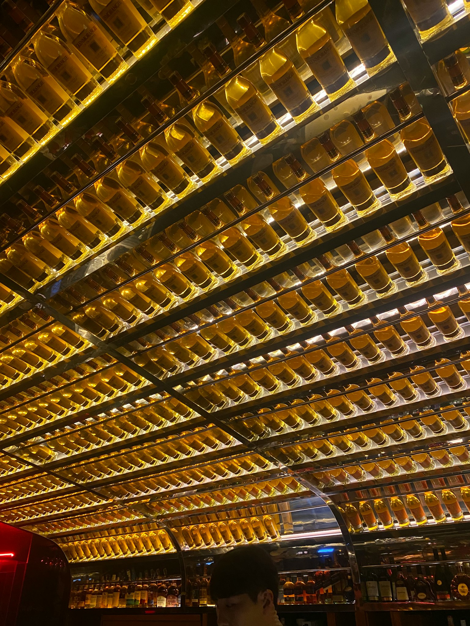 Un soffitto straordinario adornato di bottiglie dorate in un bar