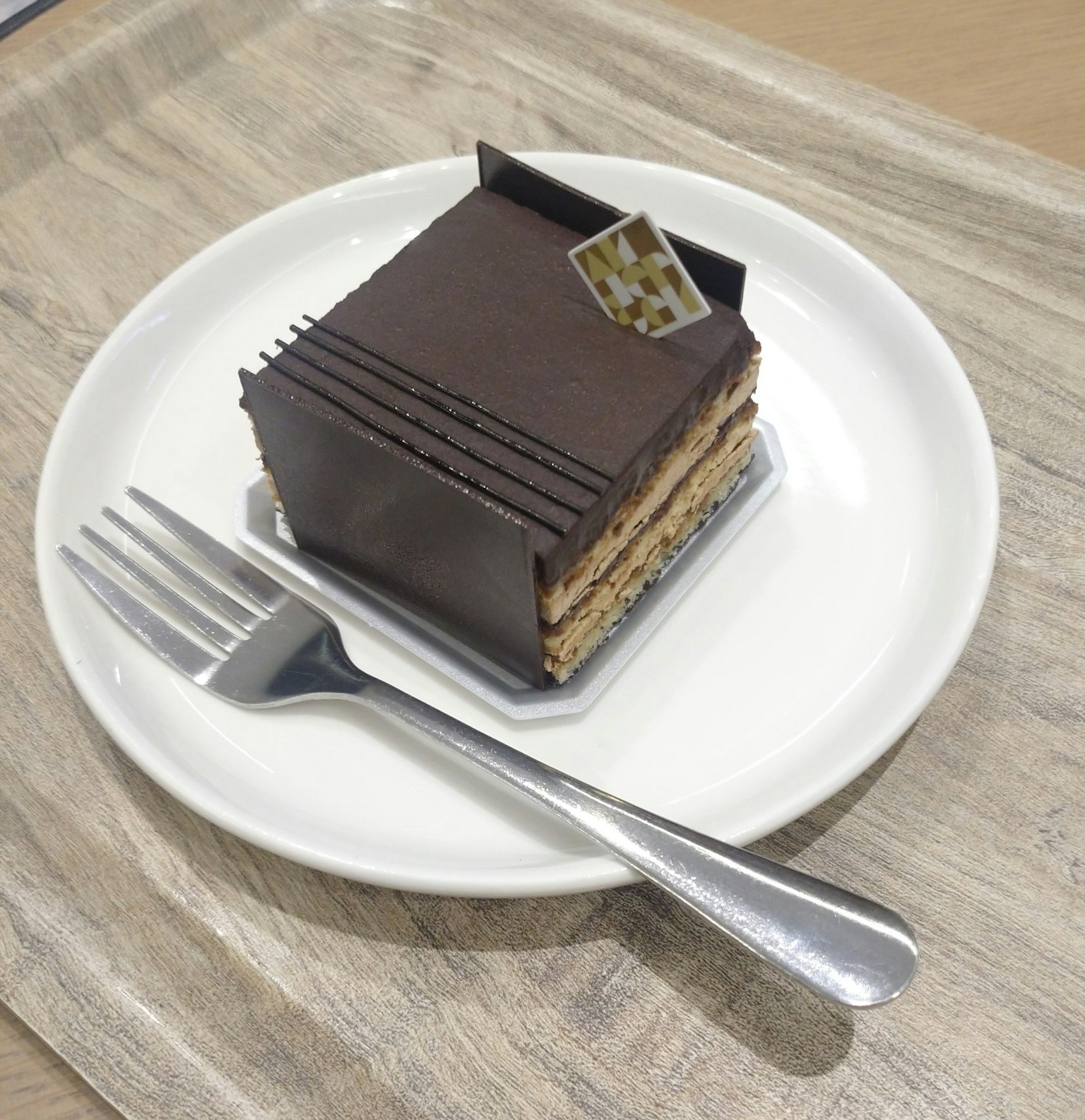 Chocolate cake served on a white plate with a fork