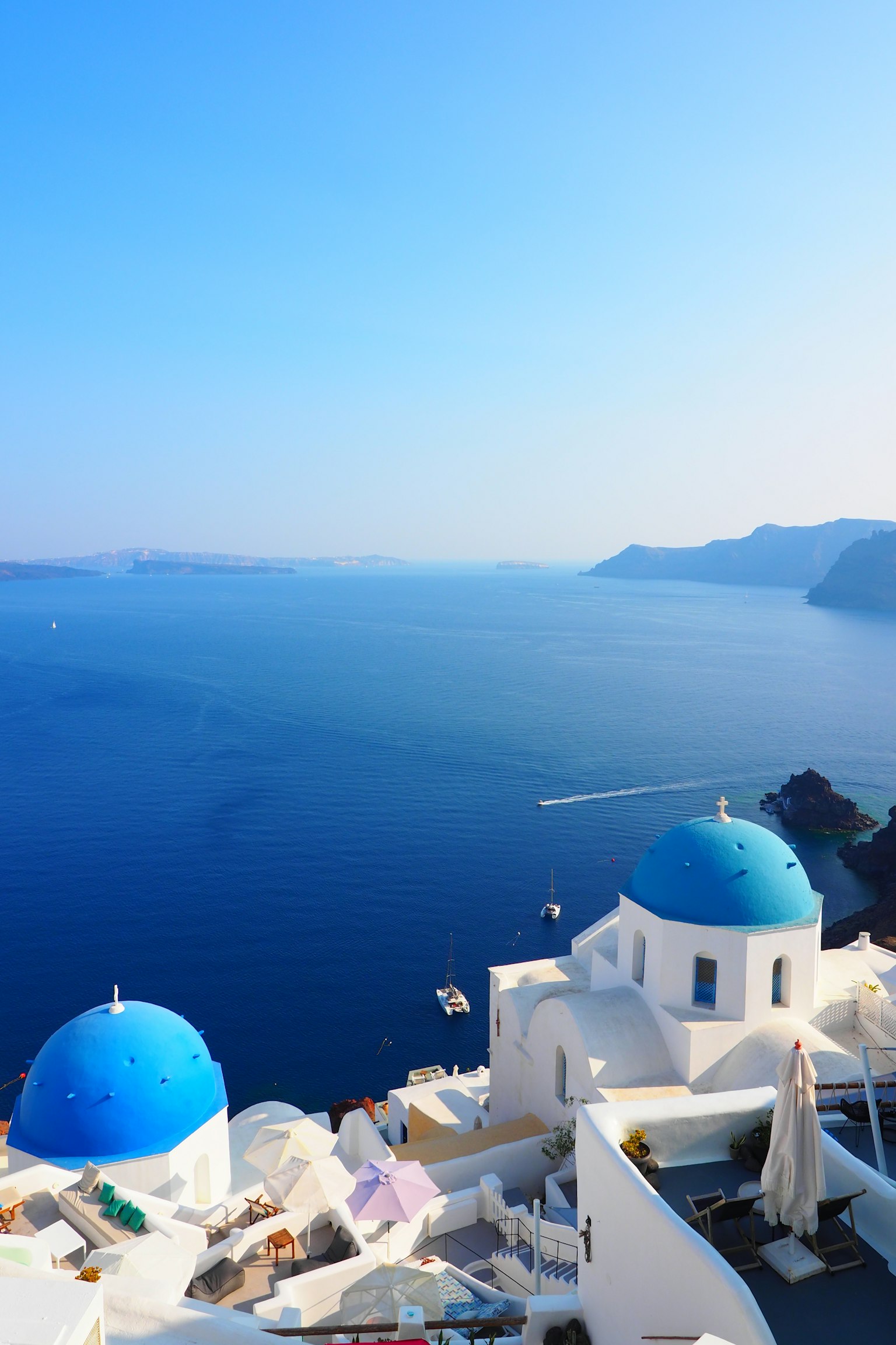 Malersicher Blick auf Kirchen mit blauen Kuppeln, die über den Ozean in Santorini blicken