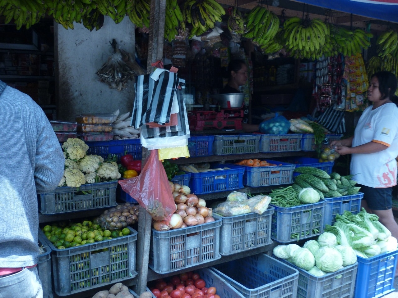 quầy rau quả ngoài đường với các loại rau và trái cây trong thùng nhựa màu xanh