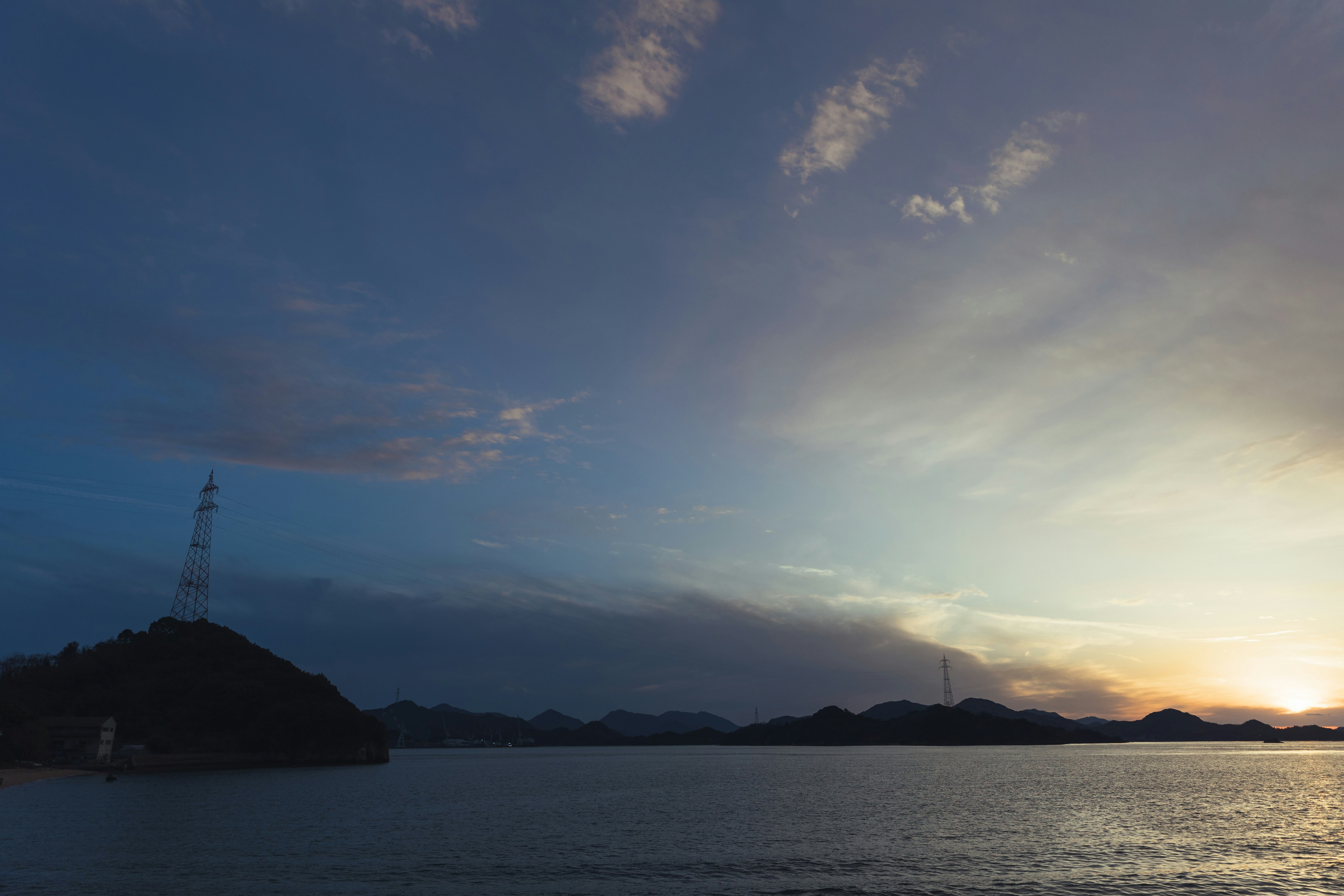 夕暮れの海辺に浮かぶ島と水平線の風景