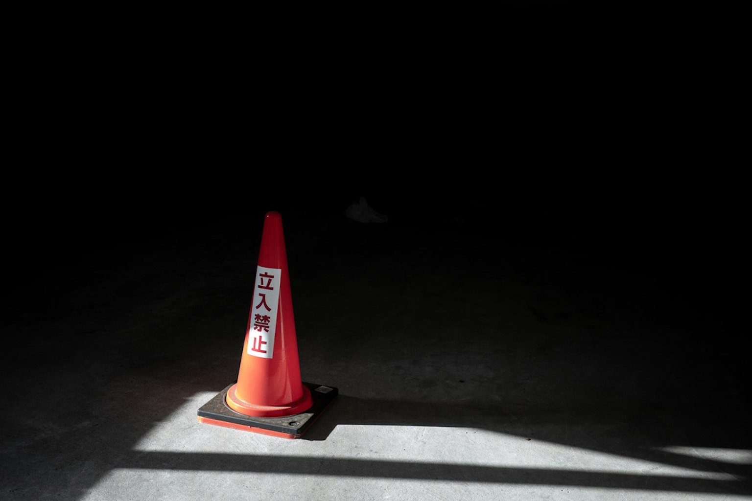 Un cône de circulation rouge avec un panneau d'interdiction dans un espace sombre