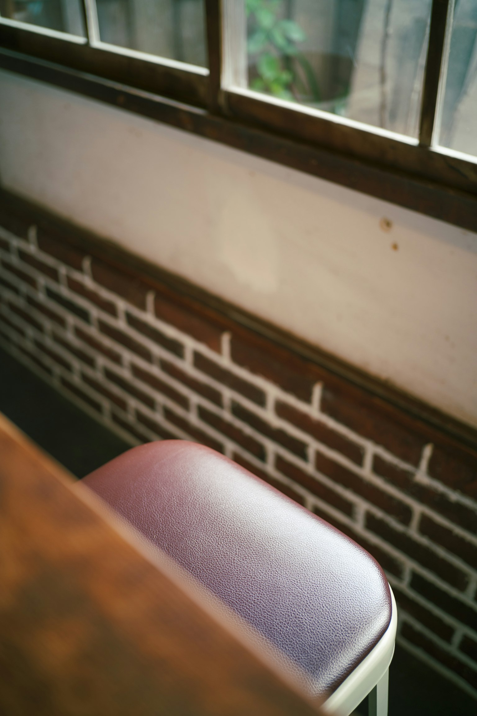 Angolo di un caffè con una sedia viola e un muro di mattoni