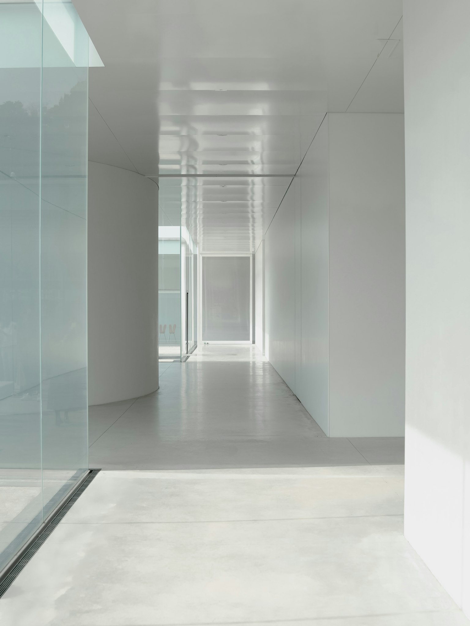 Modern hallway with white walls and glass structures