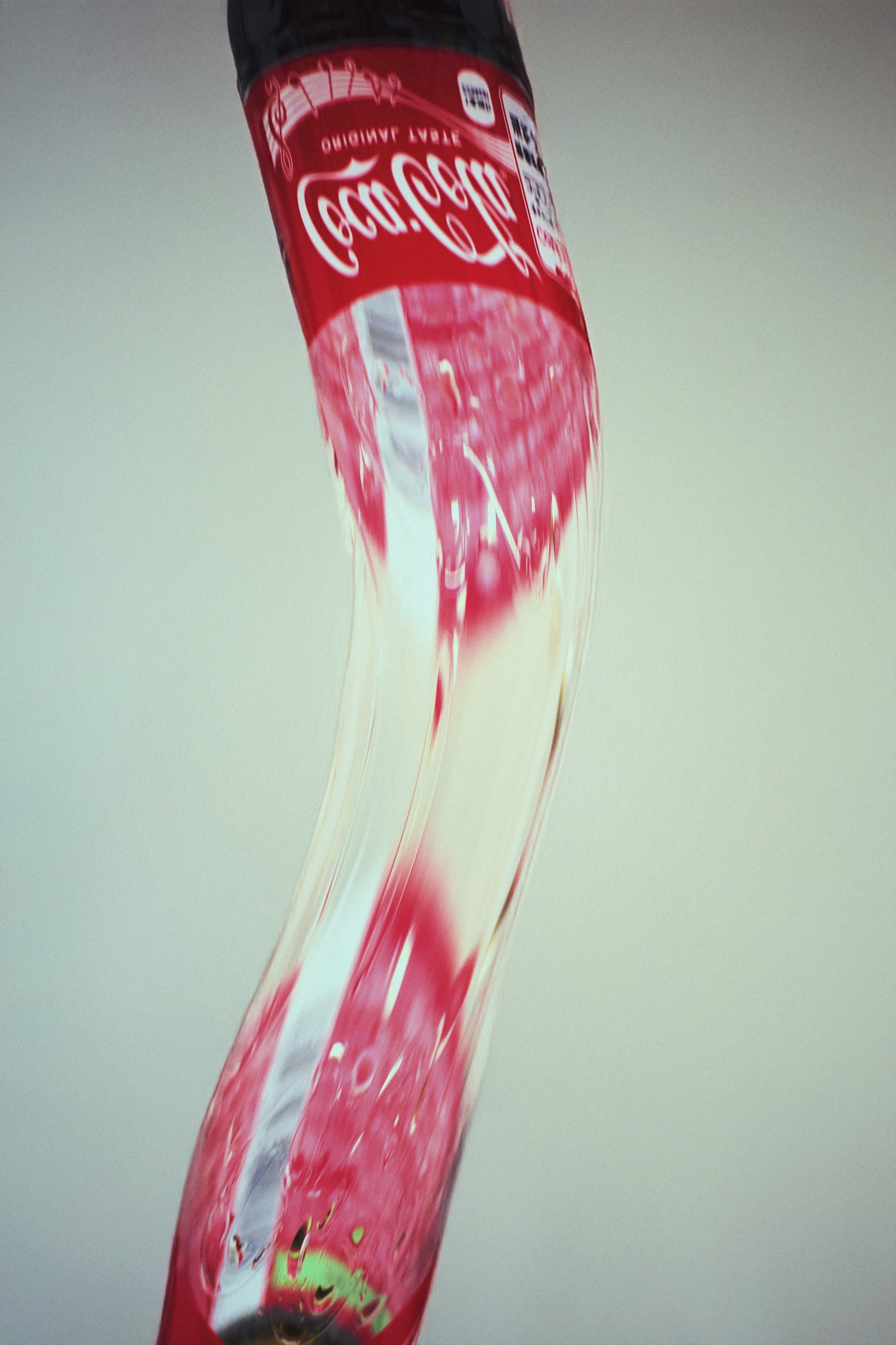 Botol Coca-Cola yang terdistorsi di latar belakang putih