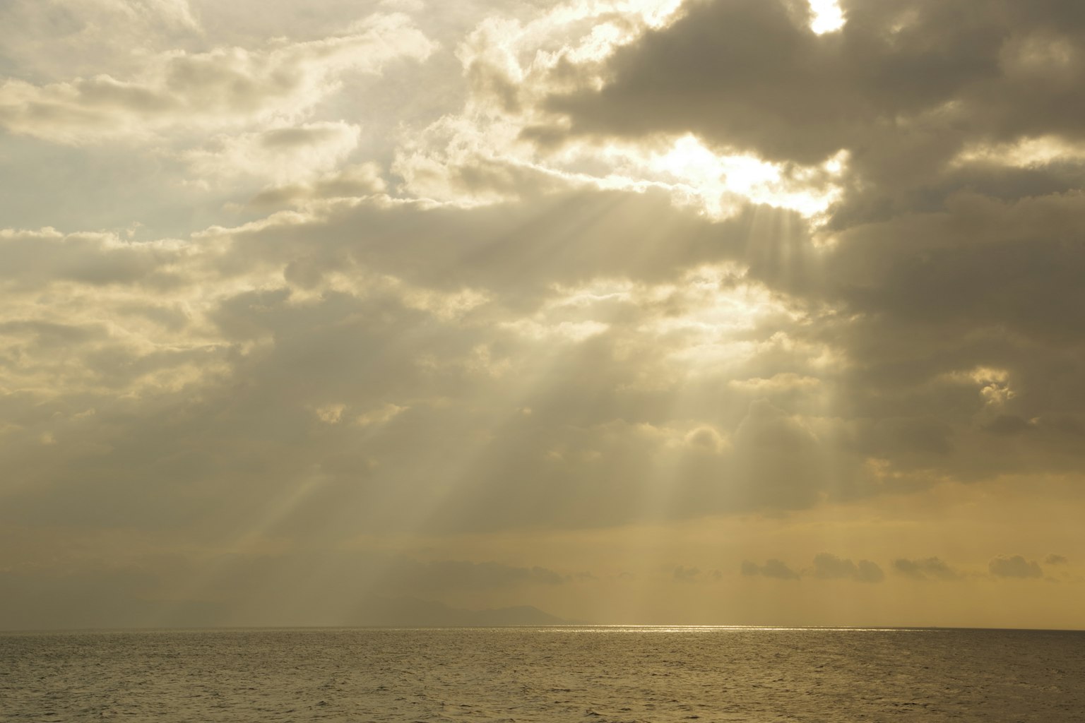 Ciel nuageux avec des rayons de lumière sur l'océan