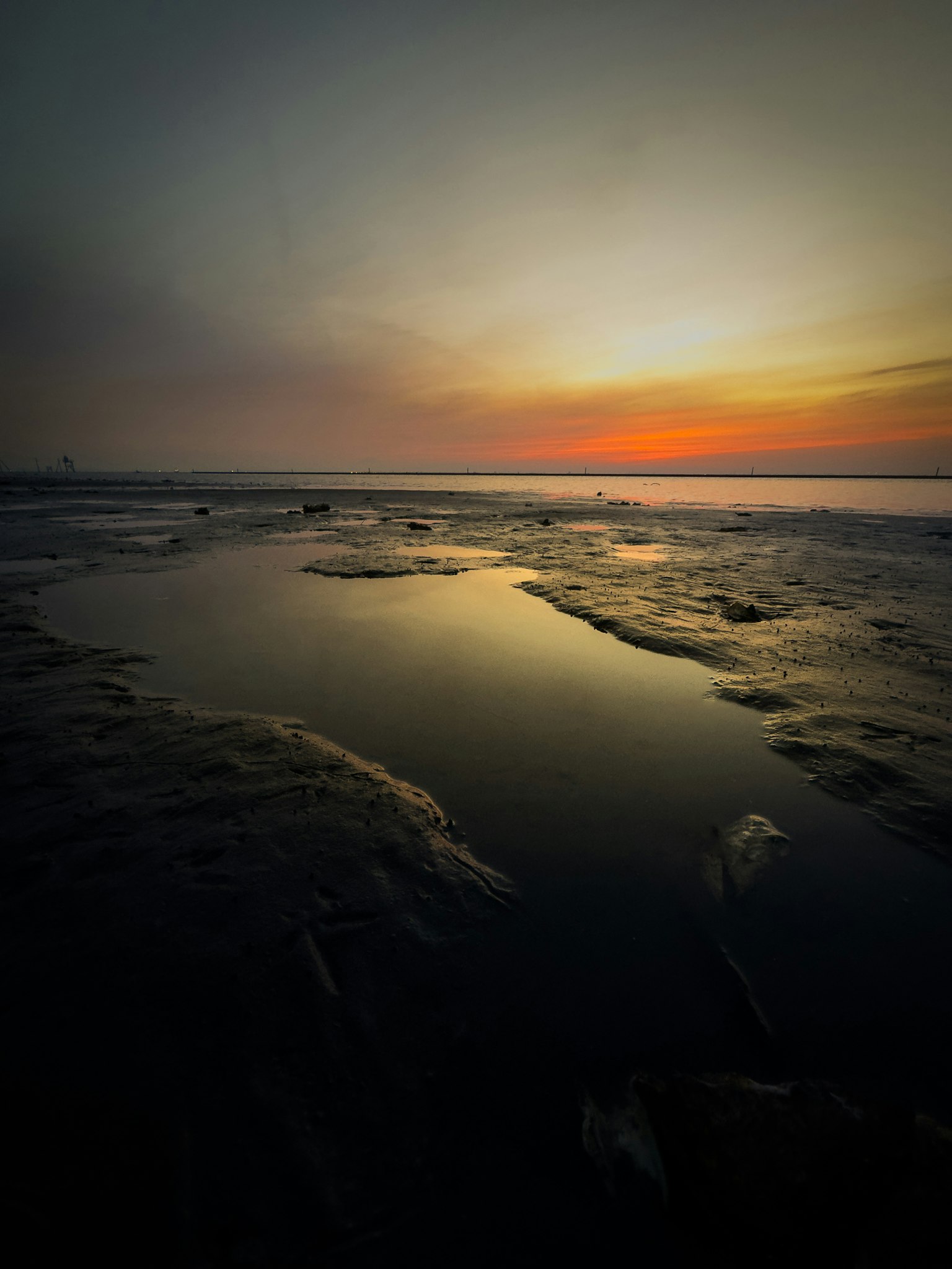 Calm beach scene with sunset reflecting on the water