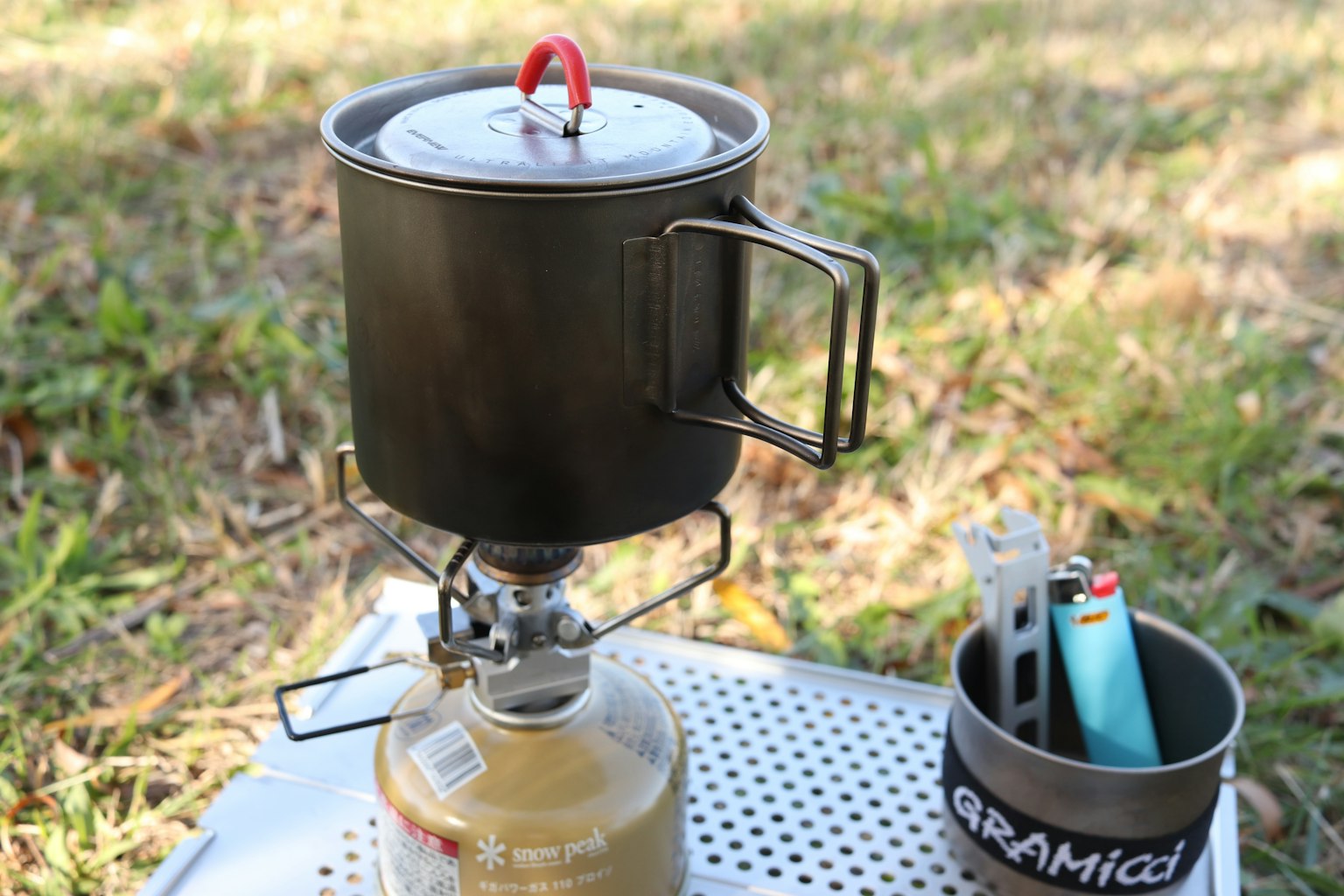 Réchaud de camping avec une casserole sur l'herbe à l'extérieur