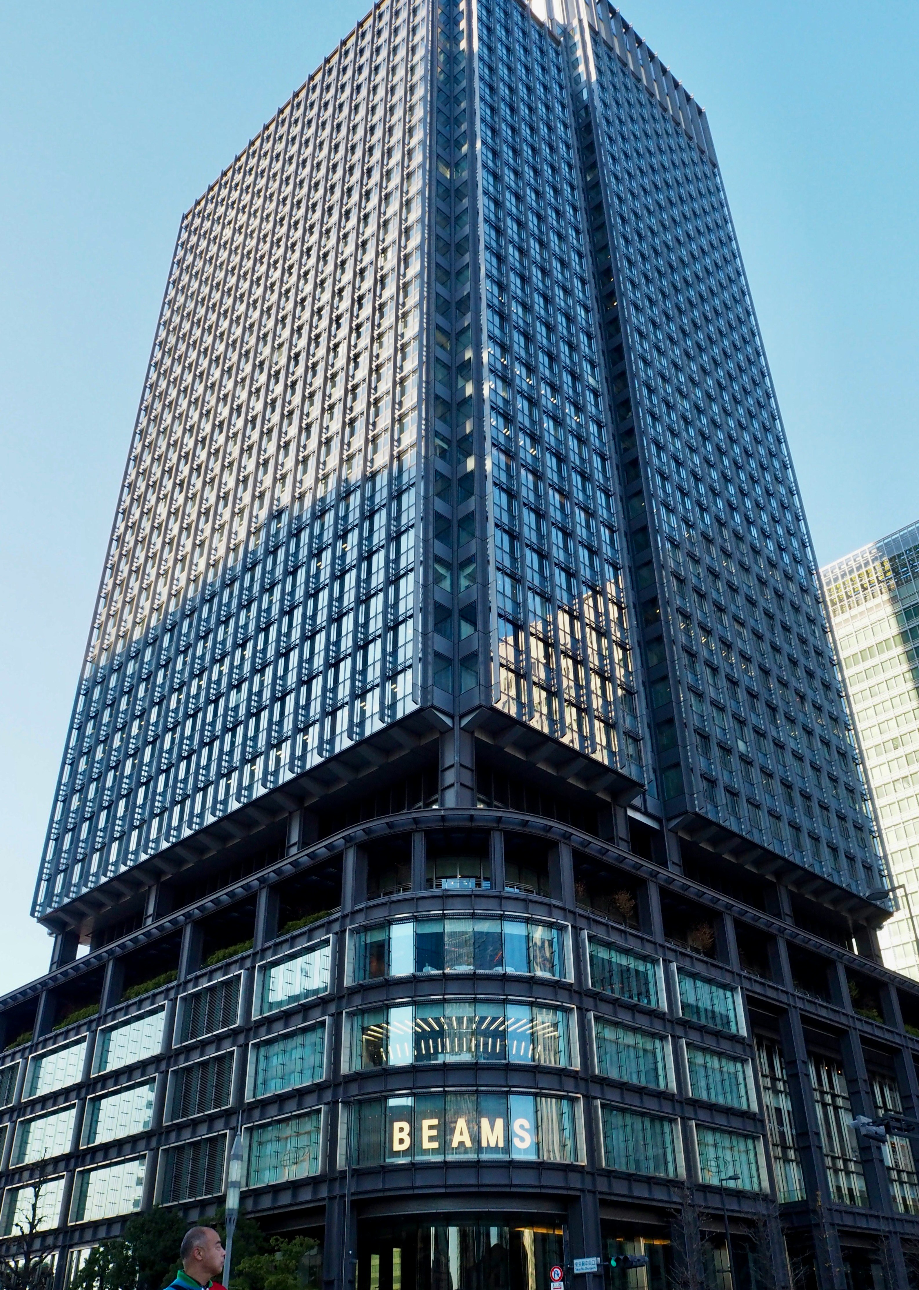 Street view of a tall building with a BEAMS sign