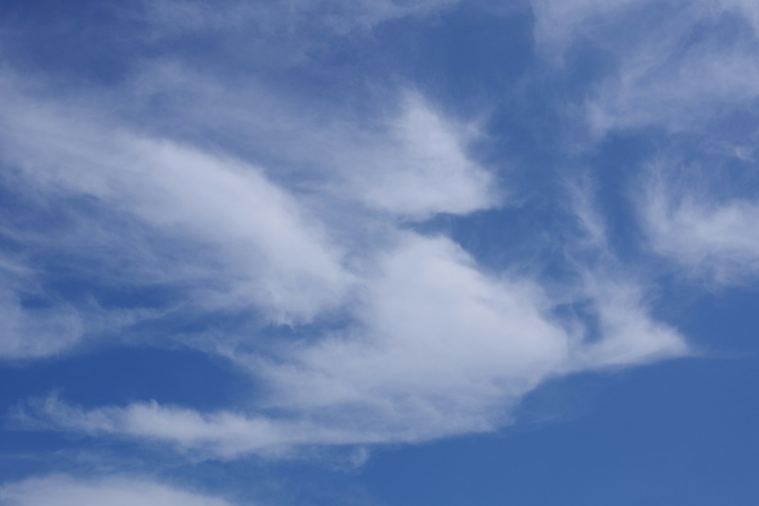 Soft cloud patterns in a bright blue sky