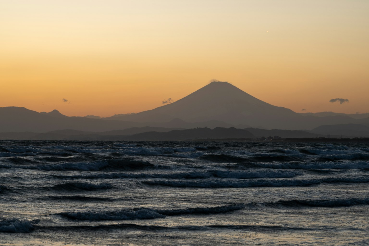 Tramonto sull'oceano con silhouette del monte Fuji