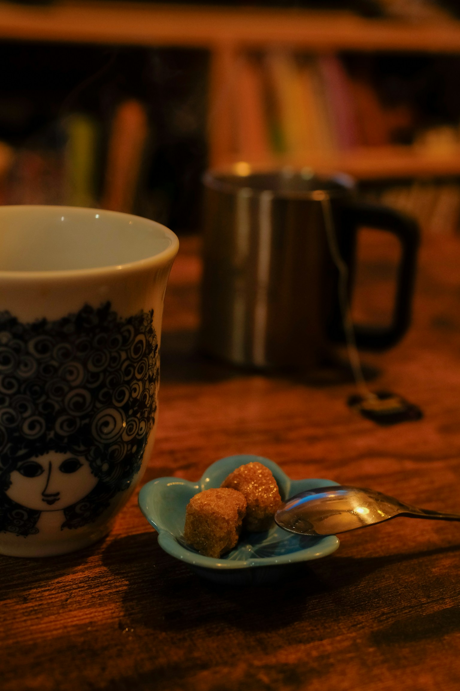 桌子上有一只装饰设计的咖啡杯和一小盘小吃