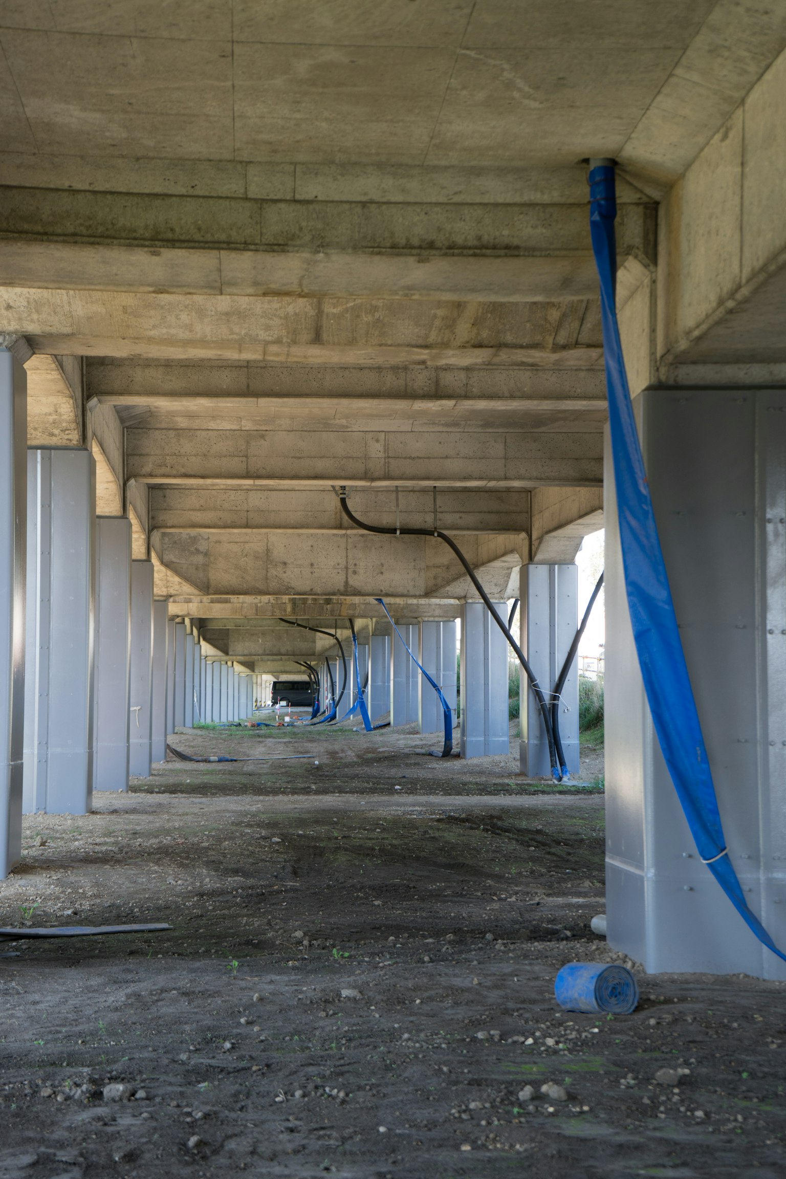 Blick unter einer Betonbrücke mit hängendem blauen Stoff