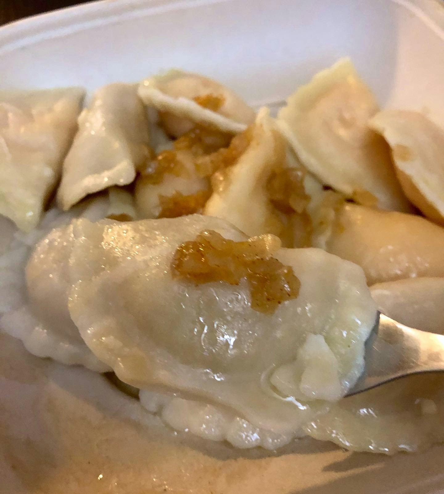 primo piano di ravioli/dumpling con ripieno dorato in un piatto