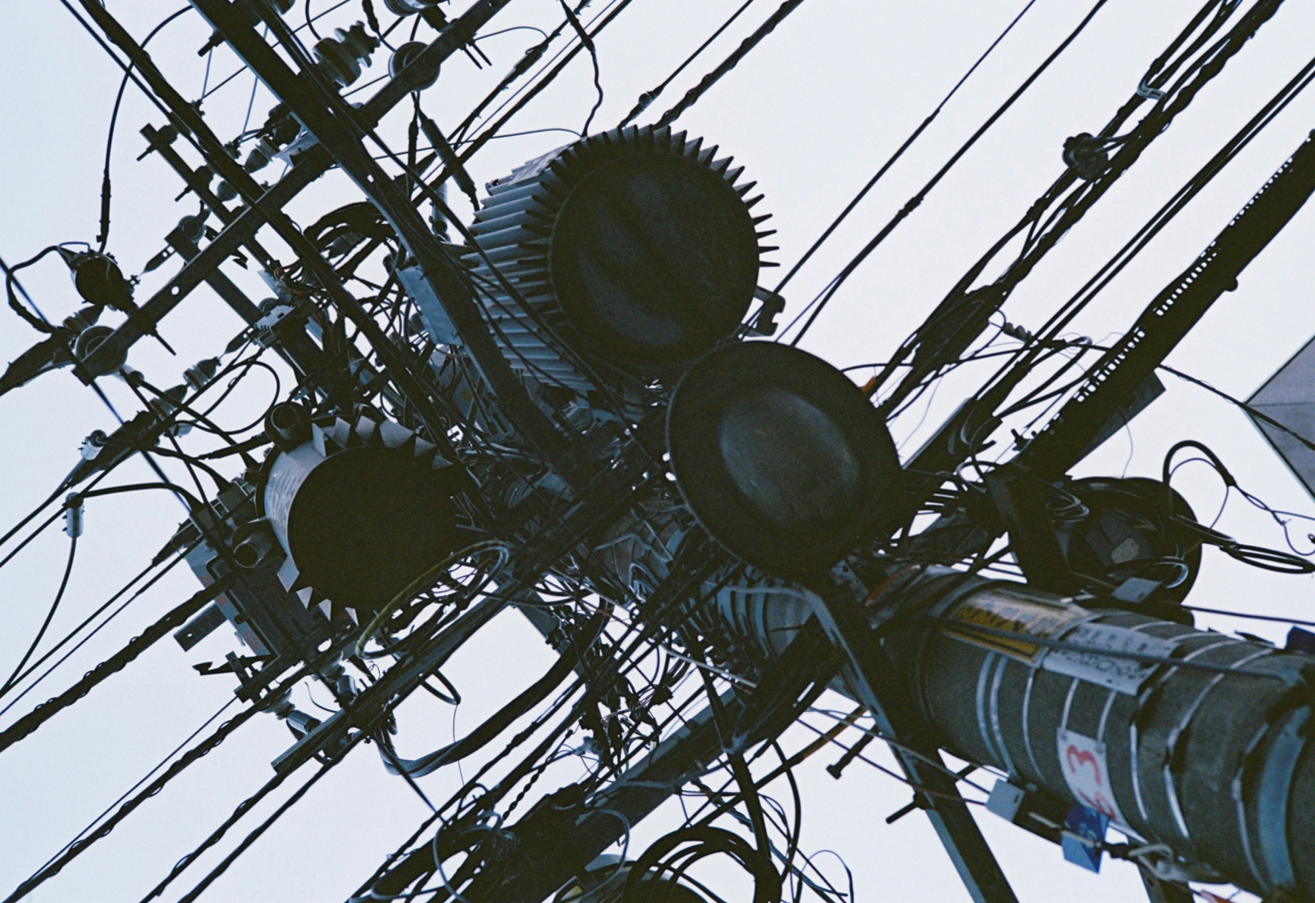 電線と街灯が交差する空の下の風景