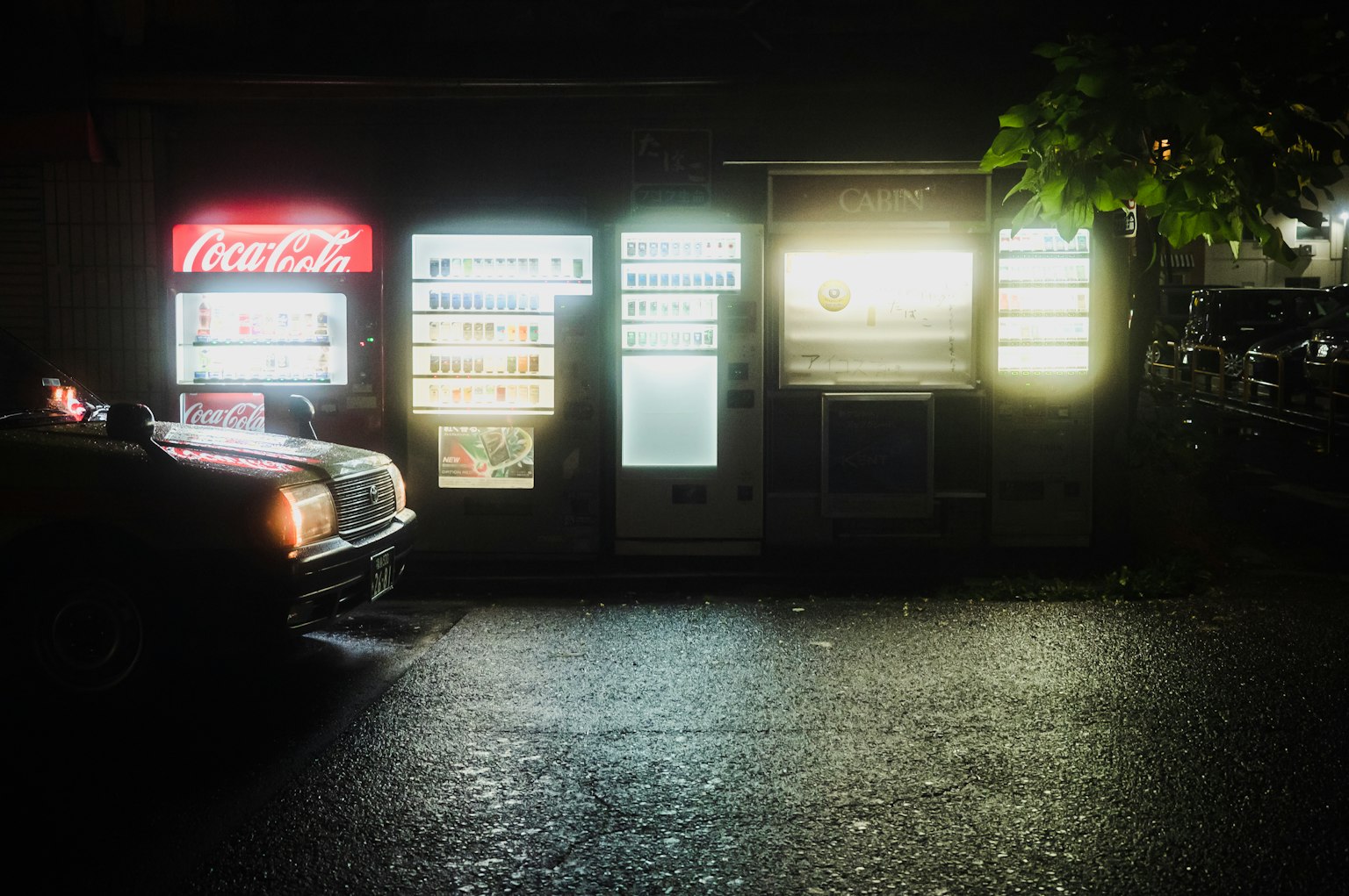 Máy bán hàng tự động sáng đèn và xe cũ vào ban đêm