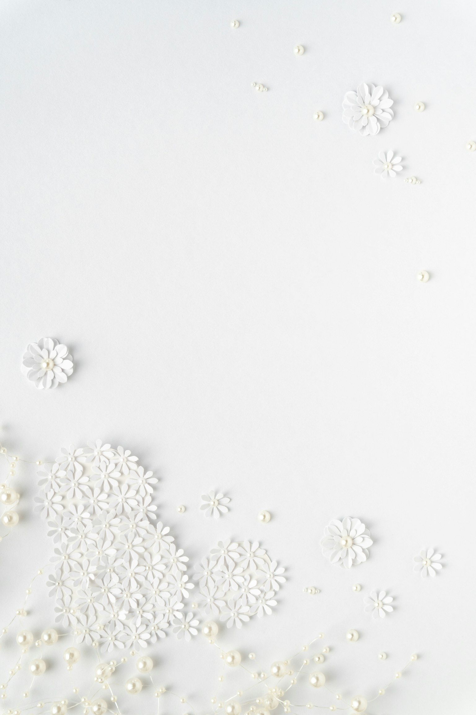 Sfondo bianco con perle bianche sparse e decorazioni a forma di fiore