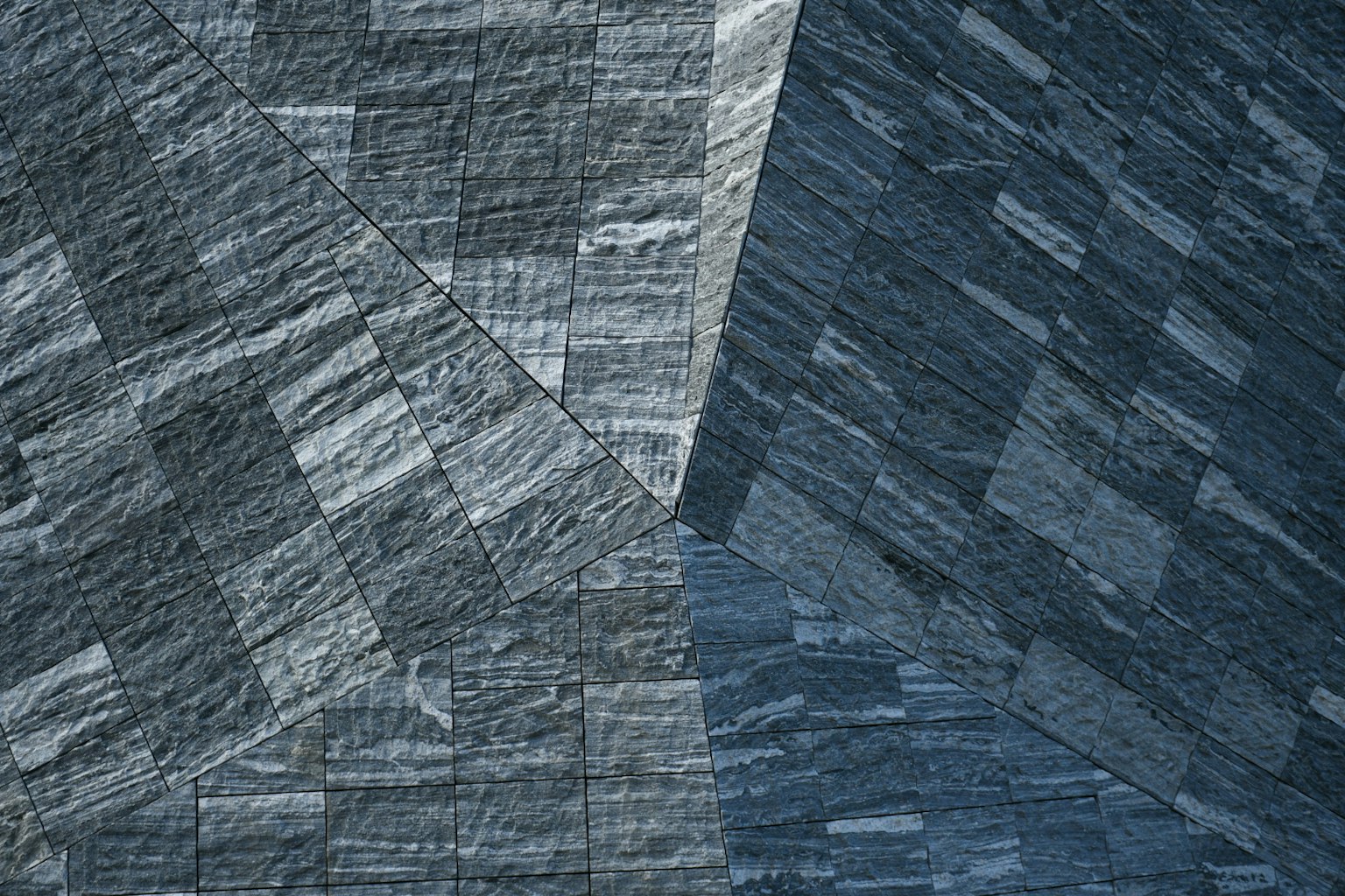 Abstract pattern of intersecting slate textures in shades of blue and gray
