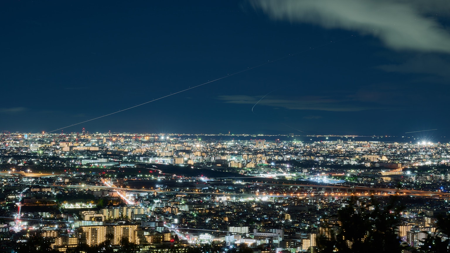 Paisaje urbano nocturno con edificios brillantes y calles iluminadas