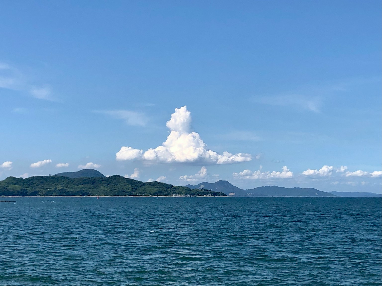 蓝色海洋和天空的风景，白云和山脉