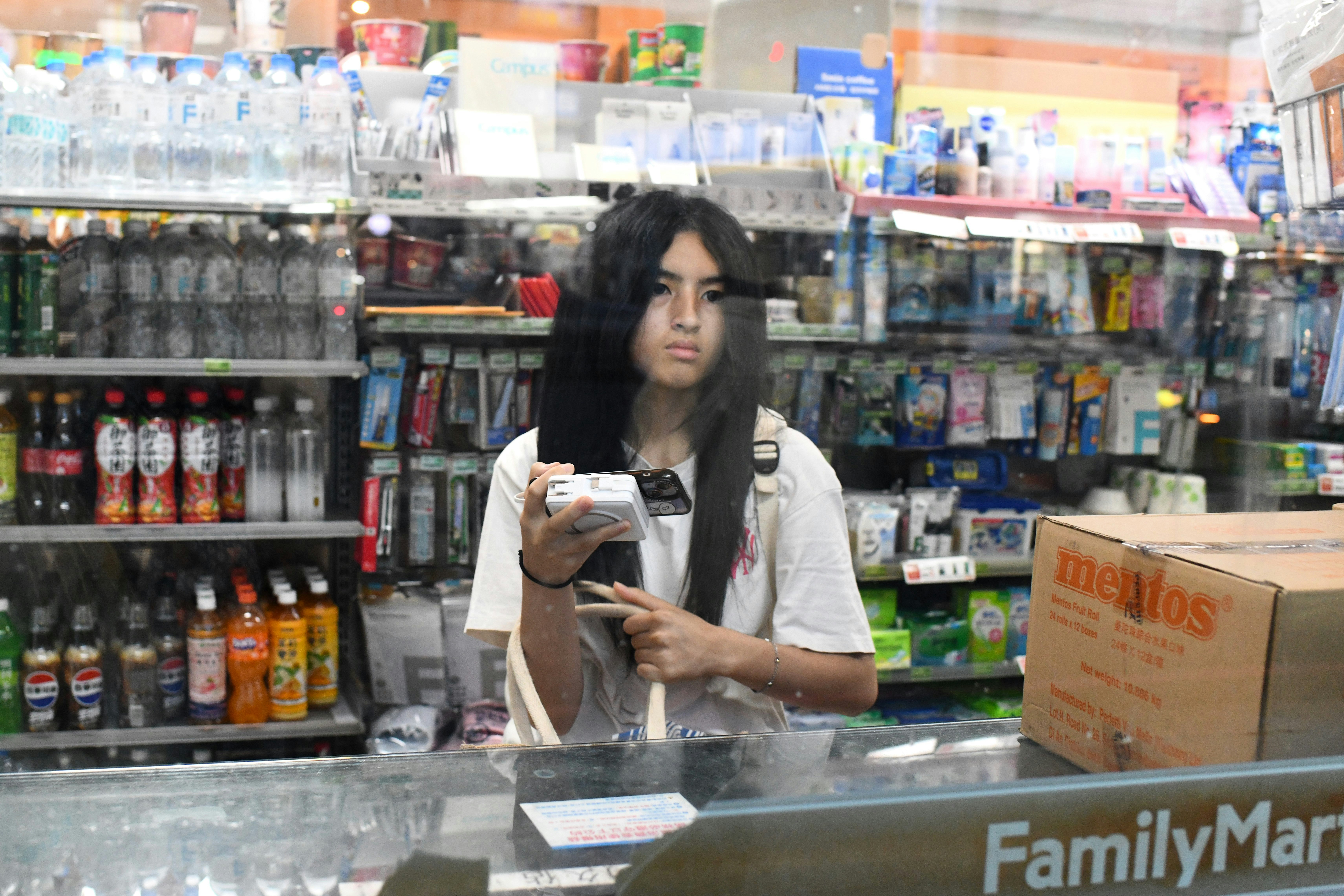 店内の棚の前で商品を手に持つ女性