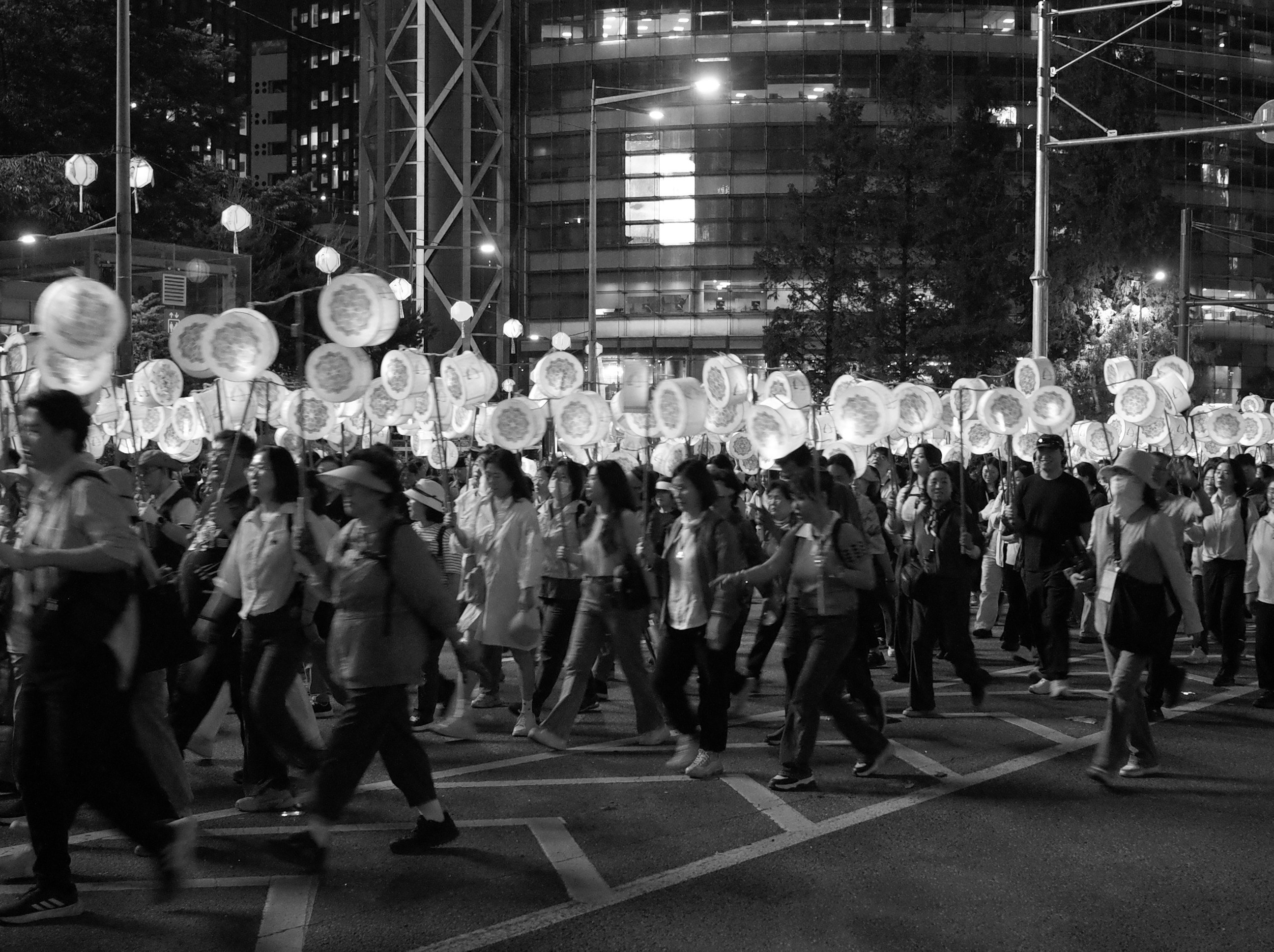 夜の街で行列する人々と提灯の灯り