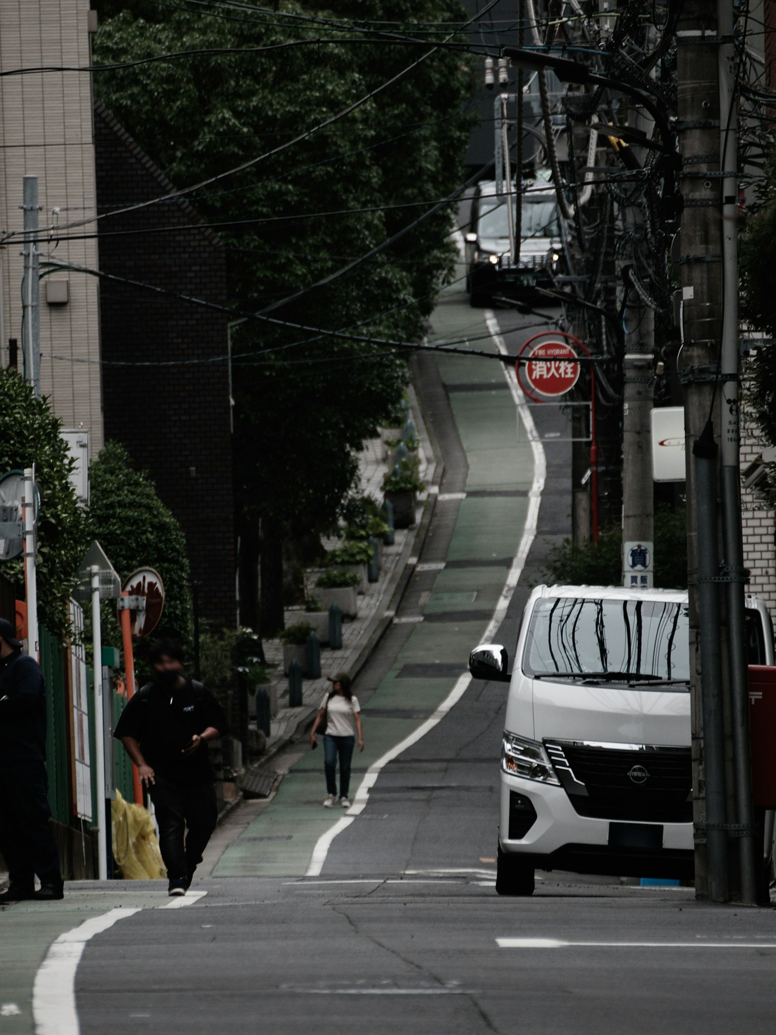 街道場景，展示了一個人在狹窄的道路上走，旁邊有一輛車