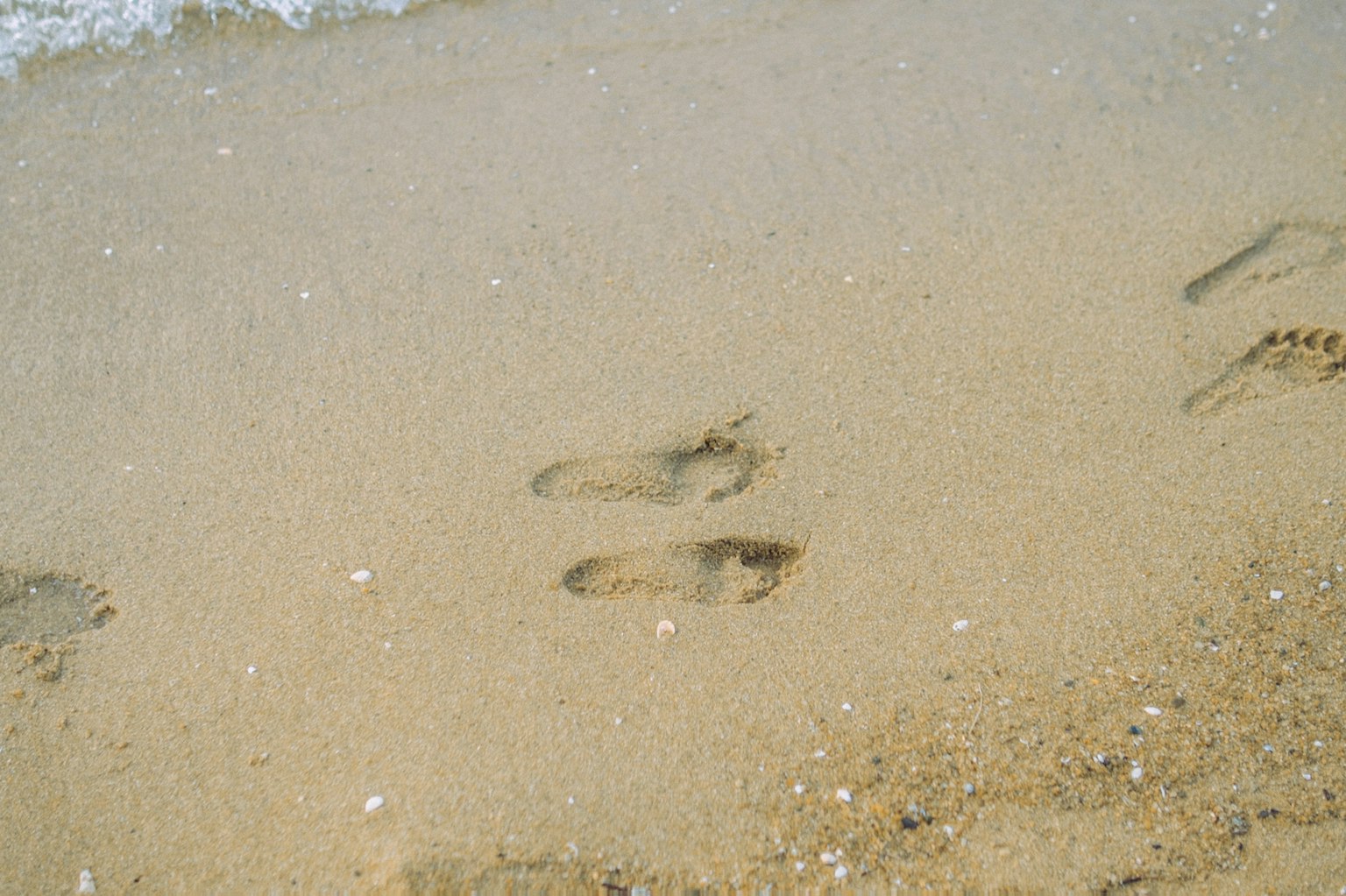 Gros plan de traces de pas sur une plage de sable