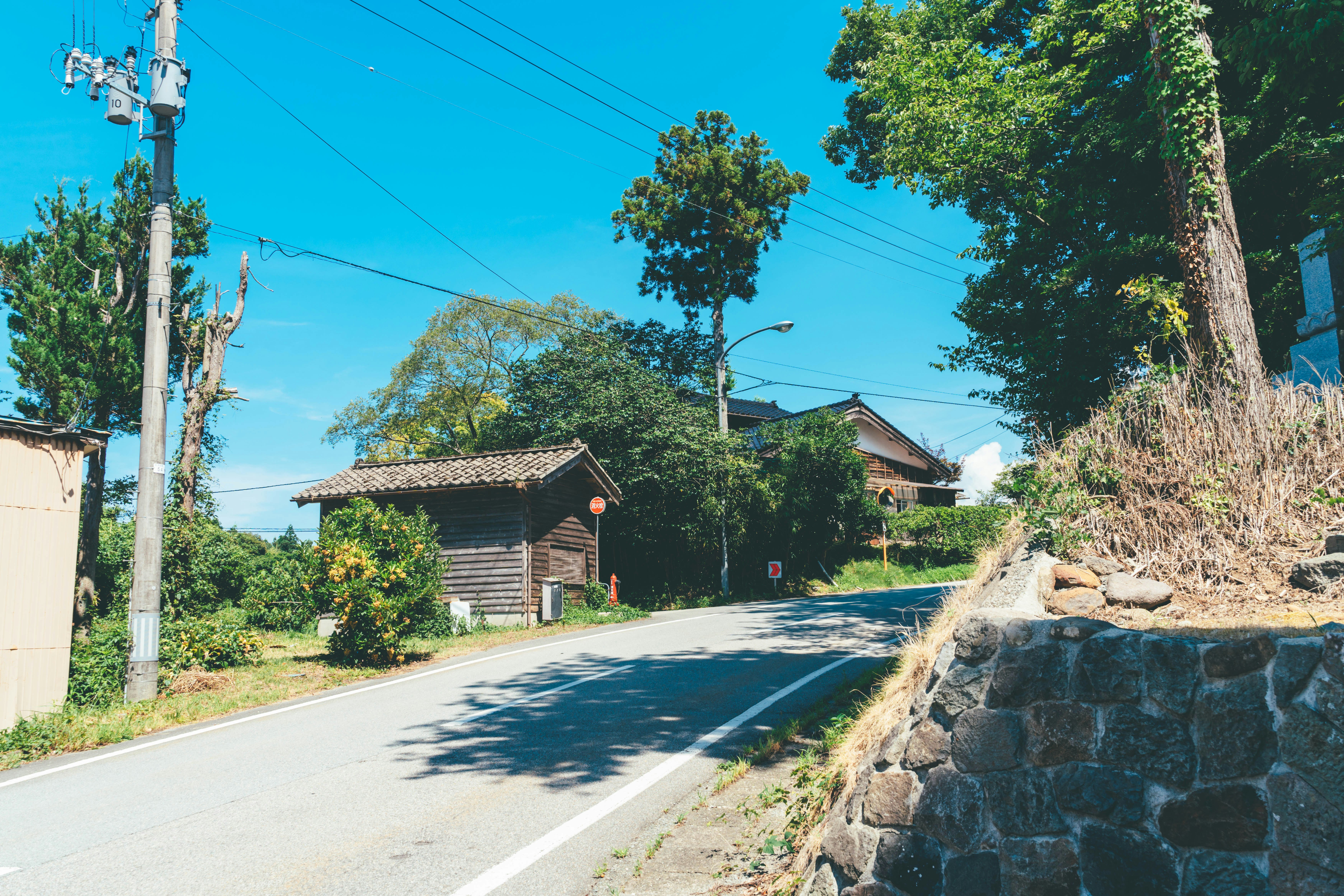 乡间道路旁的石墙、房屋与树木