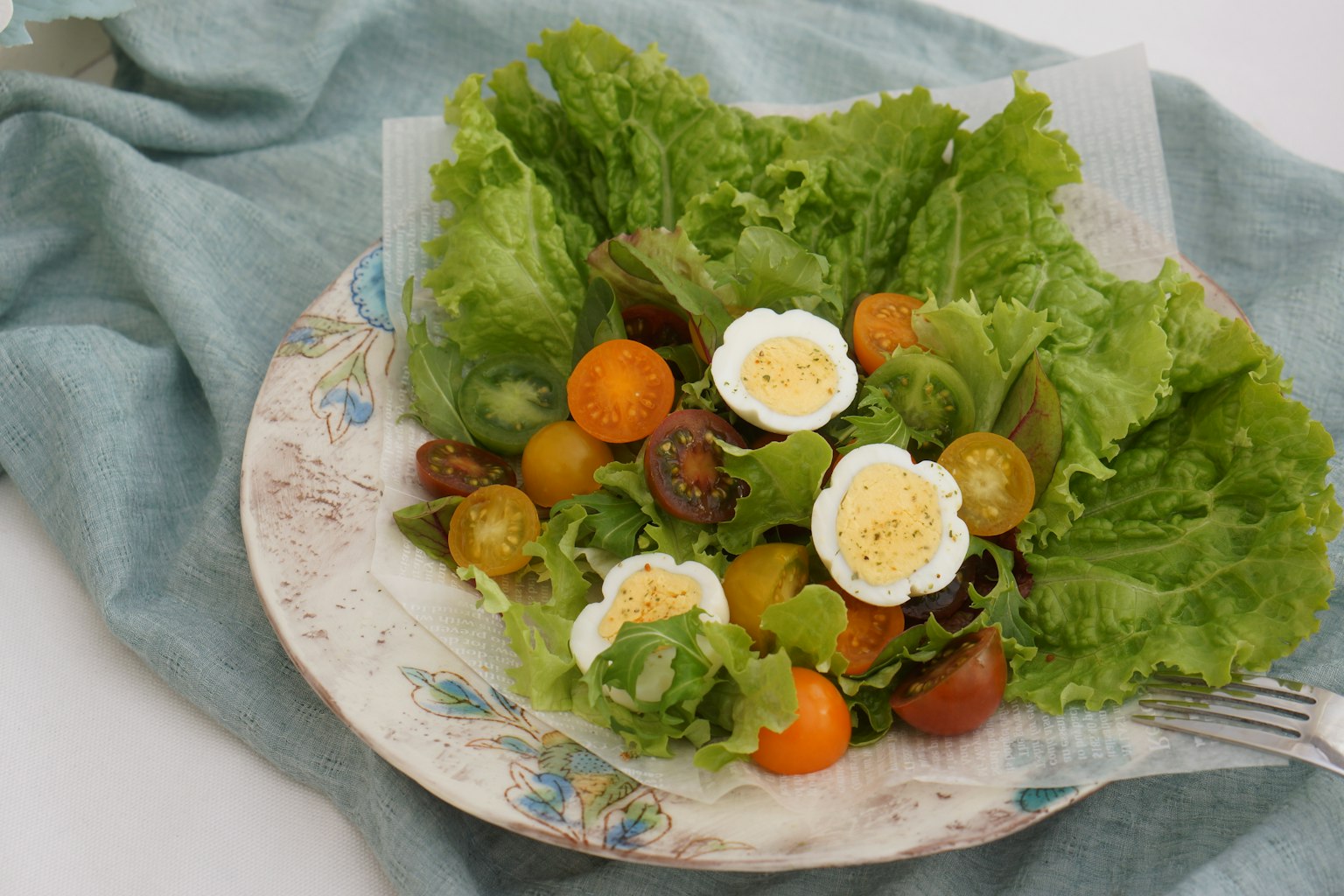 Une assiette de salade de laitue fraîche avec des tomates cerises et des œufs durs garnis