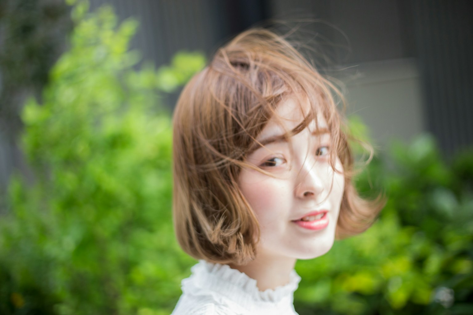 一位女性的肖像在绿色背景下头发被风吹动
