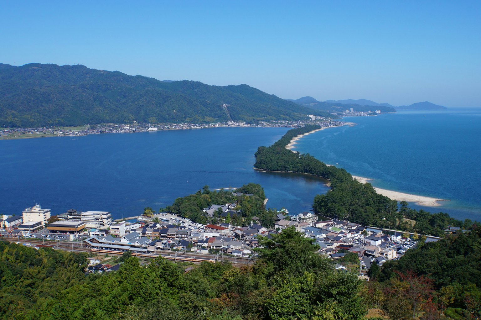 Pemandangan panorama sebuah kota pesisir dengan latar belakang pegunungan