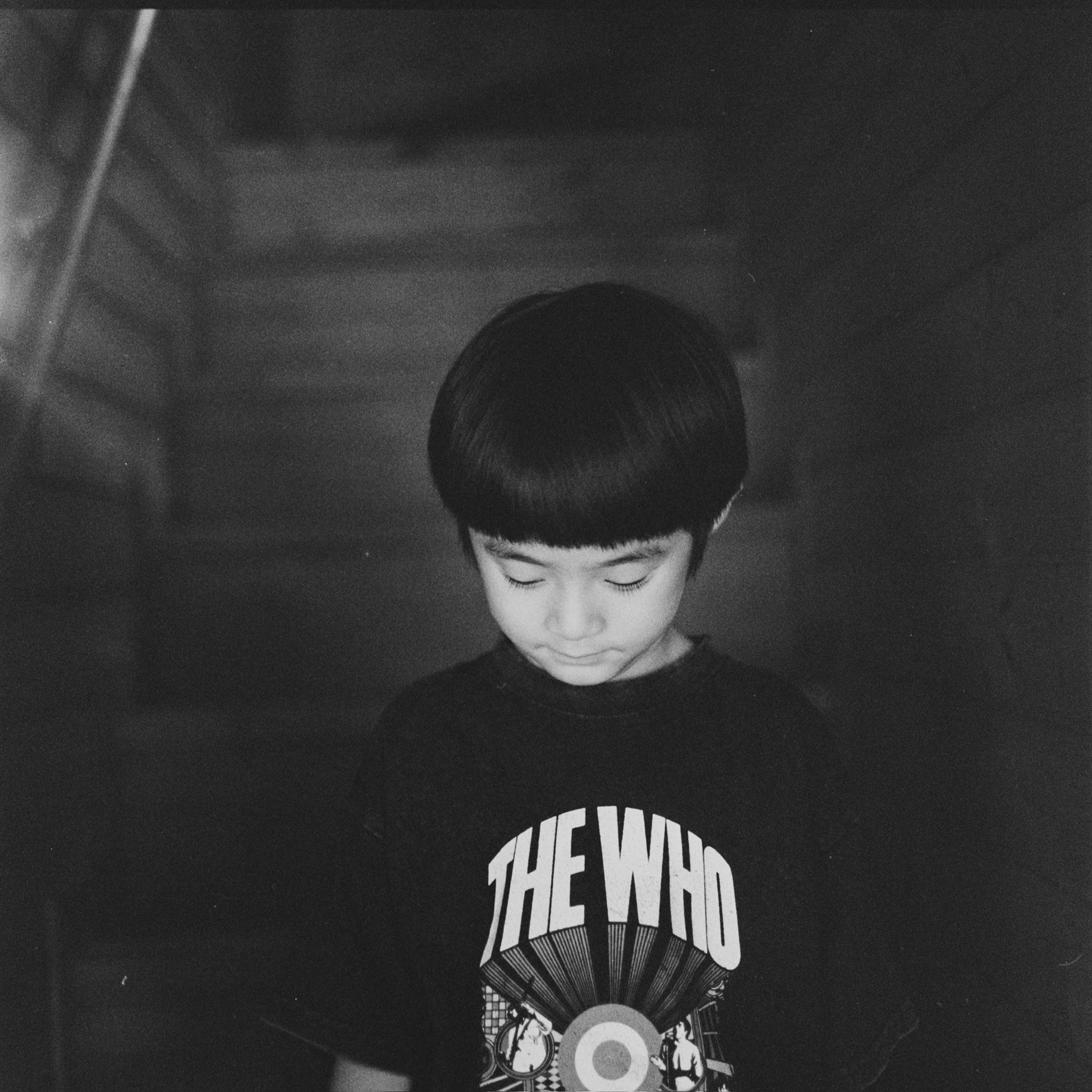 Porträt eines Jungen im schwarzen T-Shirt mit Blick nach unten